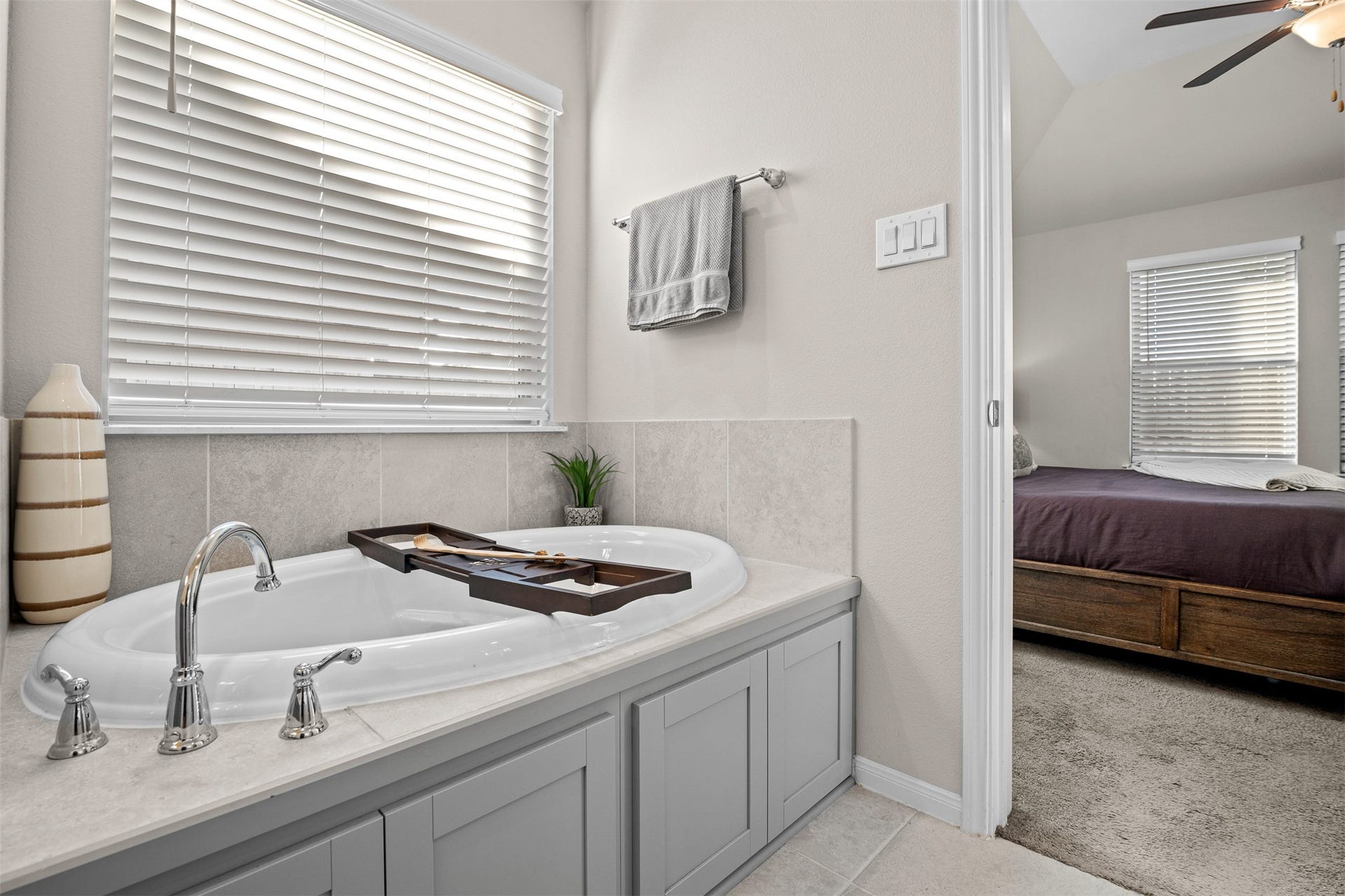 3707 Amoroso Drive, Iowa Colony, TX 77583 Your invitation to slow down: a soaking tub with a bath tray ready for a little downtime.