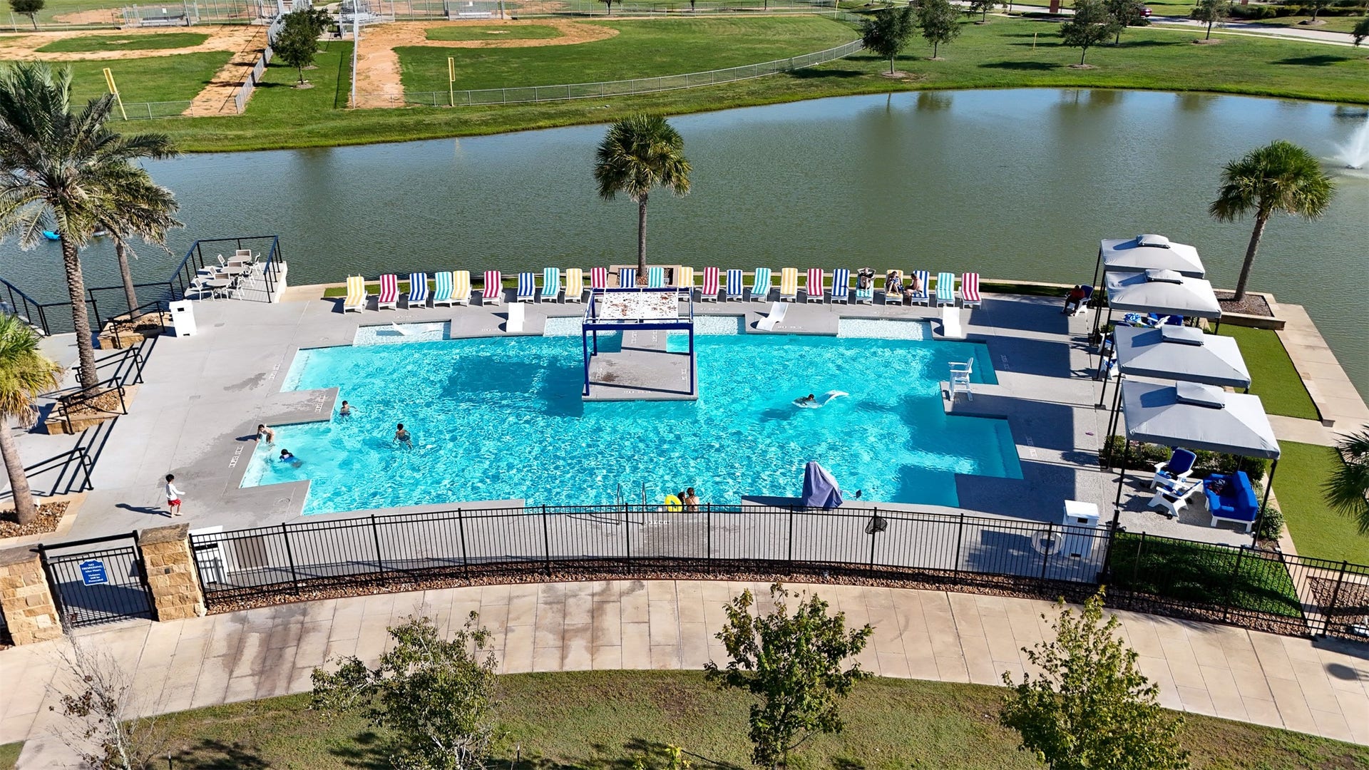 3707 Amoroso Drive, Iowa Colony, TX 77583 Poolside chairs, shaded spots, and lake views...your afternoon reset looks great from here!