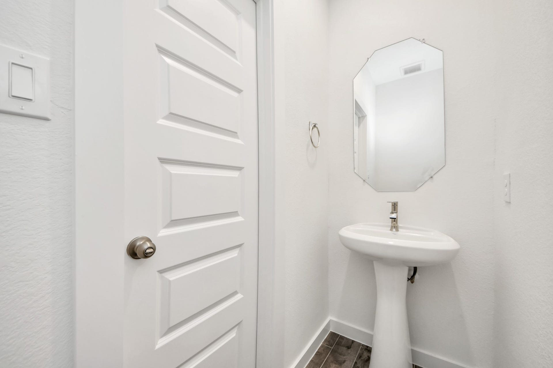 16006 Sycamore Maple Lane, Cypress, TX 77429 This half bathroom features a stylish pedestal sink, modern hardware, and bright recessed lighting, creating a sleek and inviting space. Sample photo of completed home with similar floor plan. Actual colors and selections may vary.