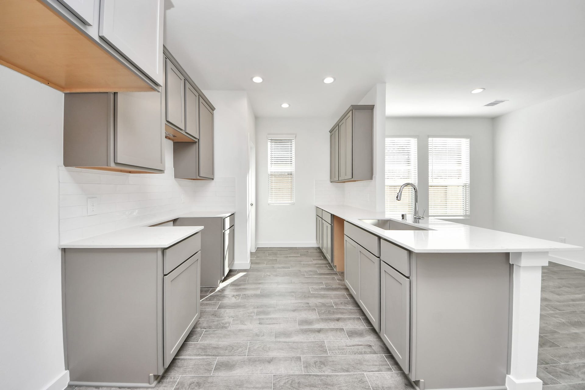 16006 Sycamore Maple Lane, Cypress, TX 77429 Culinary haven, featuring granite countertops, a tile backsplash, stainless steel appliances (to be installed), and 42 upper cabinets. Sample photo of completed home with similar floor plan. Actual colors and selections may vary.