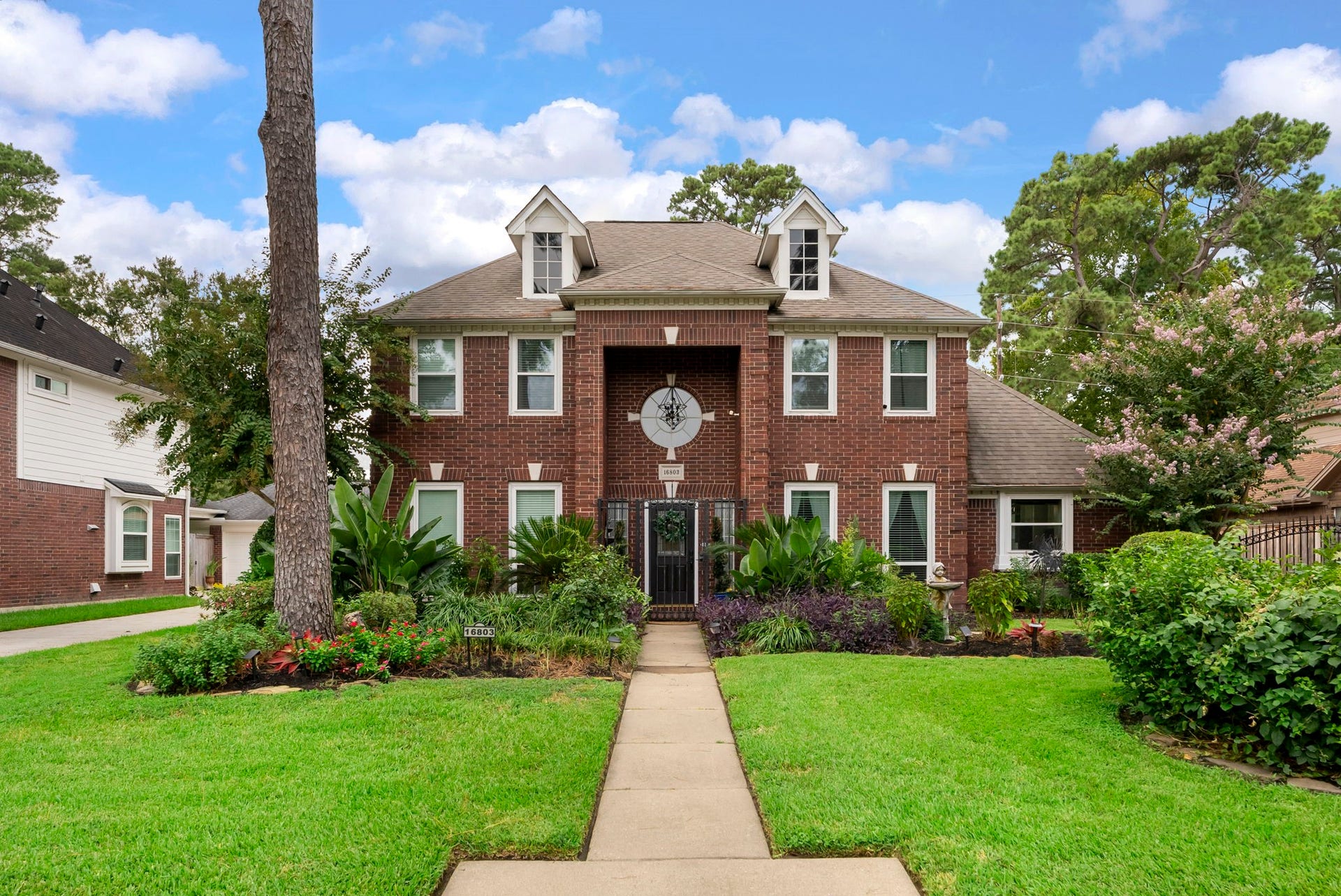 16803 Chewton Glen Street, Tomball, TX 77377 Mature trees and established landscaping frame this brick homes welcoming front elevation. A generous front lawn gives the property an inviting sense of arrival.
