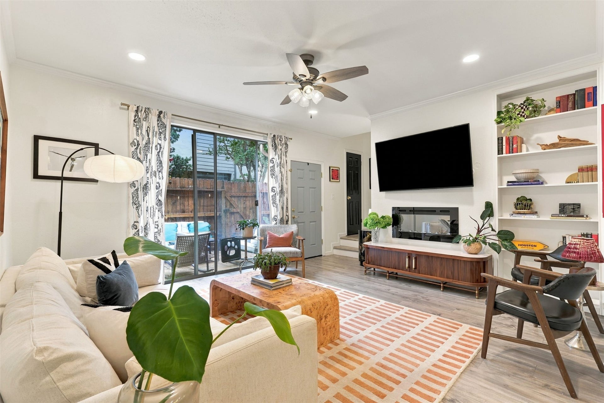 1201 Mcduffie Street, #212, Houston, TX 77019 Sliding glass doors bring daylight into the living room and lead directly to the enclosed patio.