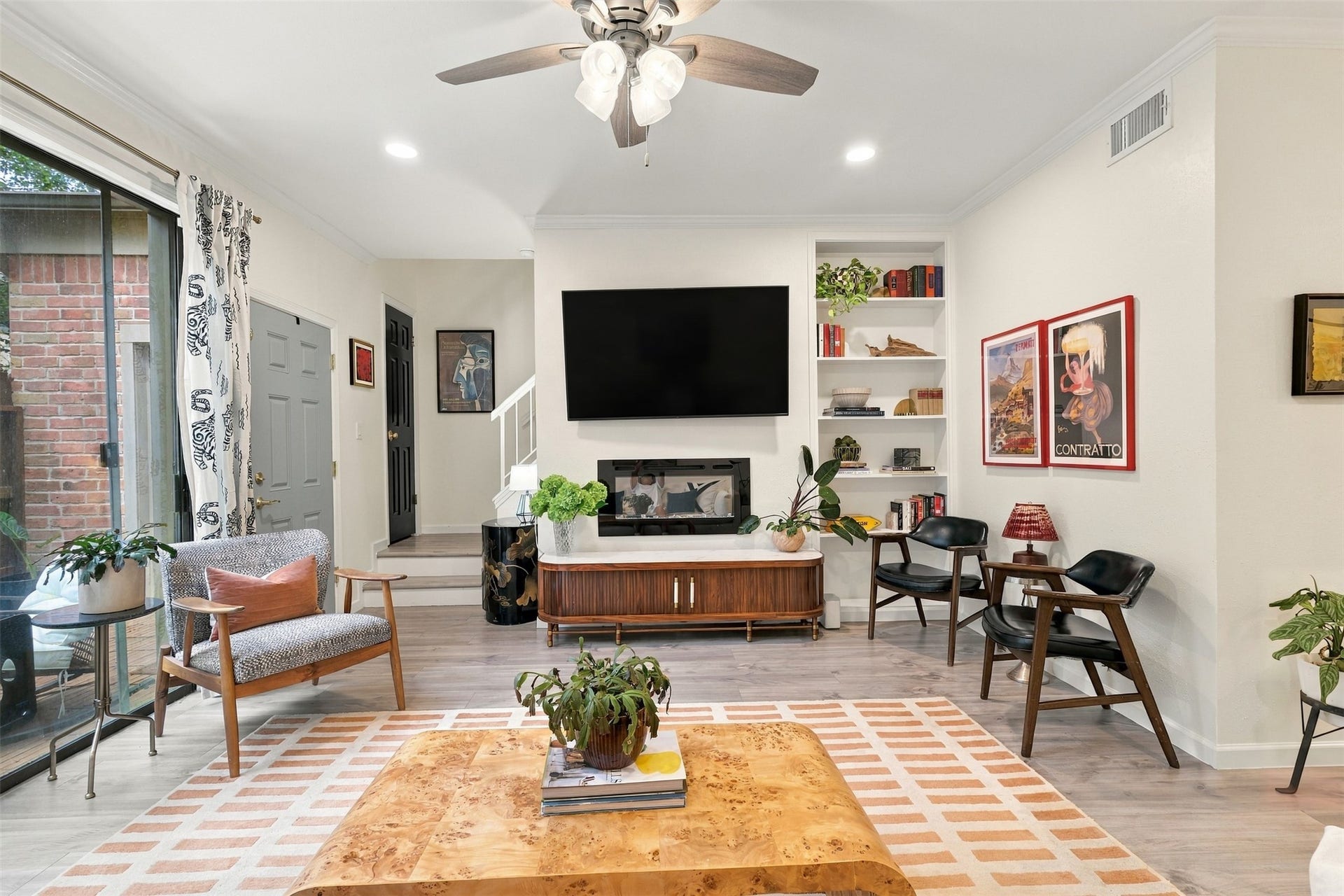 1201 Mcduffie Street, #212, Houston, TX 77019 An electric fireplace anchors the living area, with patio access just steps away.