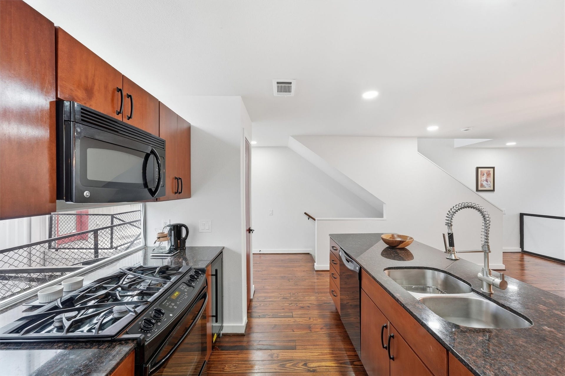 The kitchen has a window wall above and below the upper cabinets for even more light. Granite countertops. Gas range and built-in microwave. Wine fridge. Pantry.