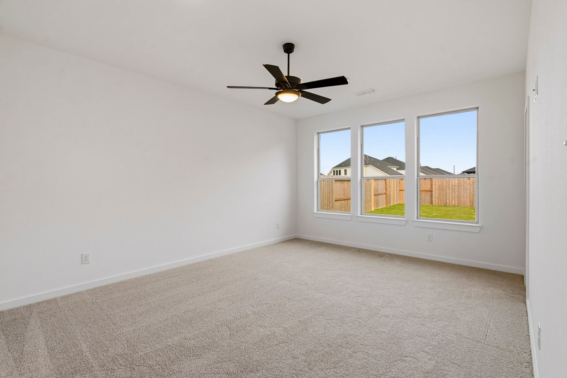 4510 Sunny Hazel Lane, Fulshear, TX 77441 Primary bedroom with three large windows overlooking the backyard.