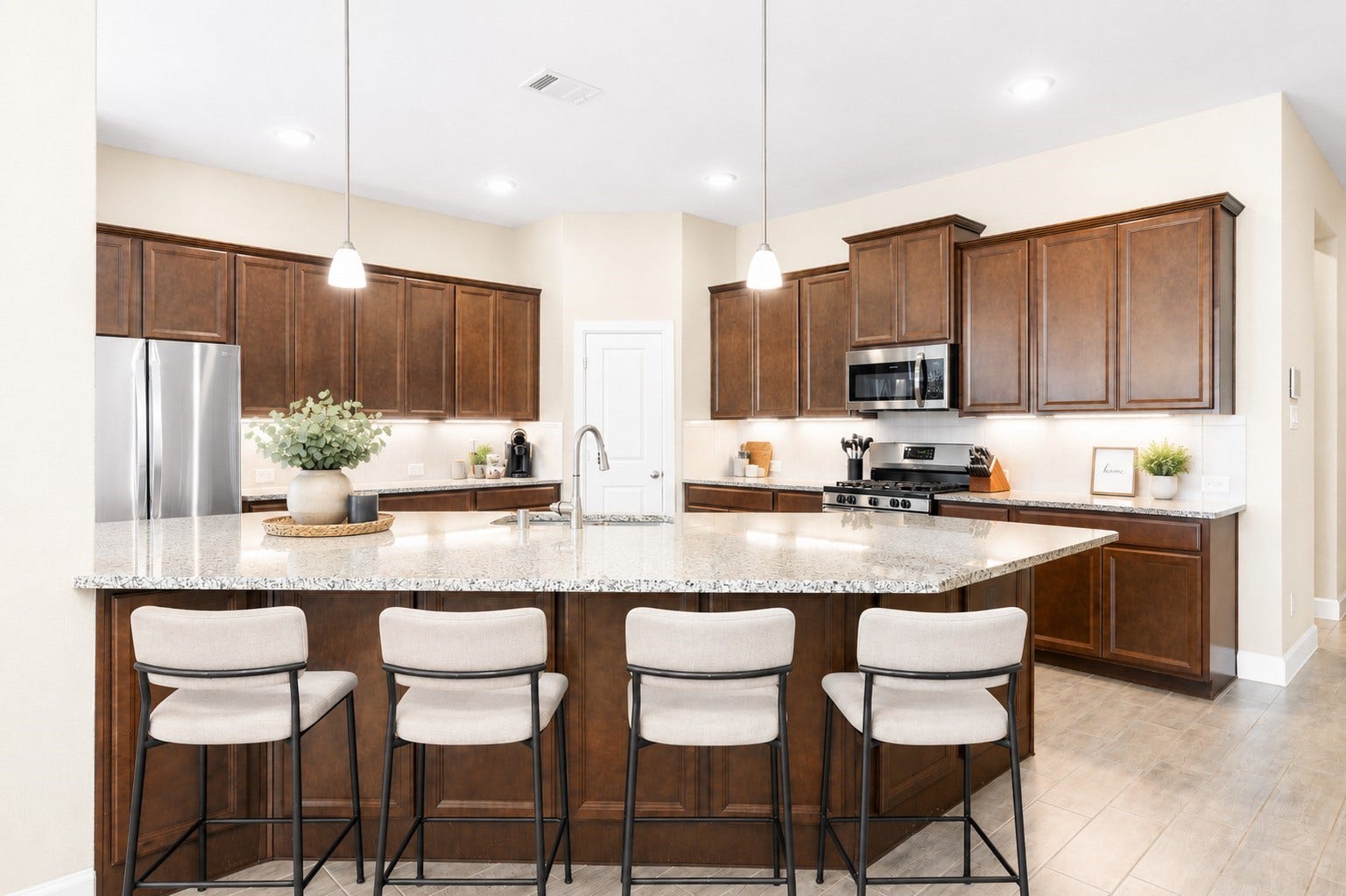 6922 Goldstrum Way, Katy, TX 77493 The kitchen features a large island with seating space, granite countertops, a tile backsplash, and updated LED under-cabinet lighting.