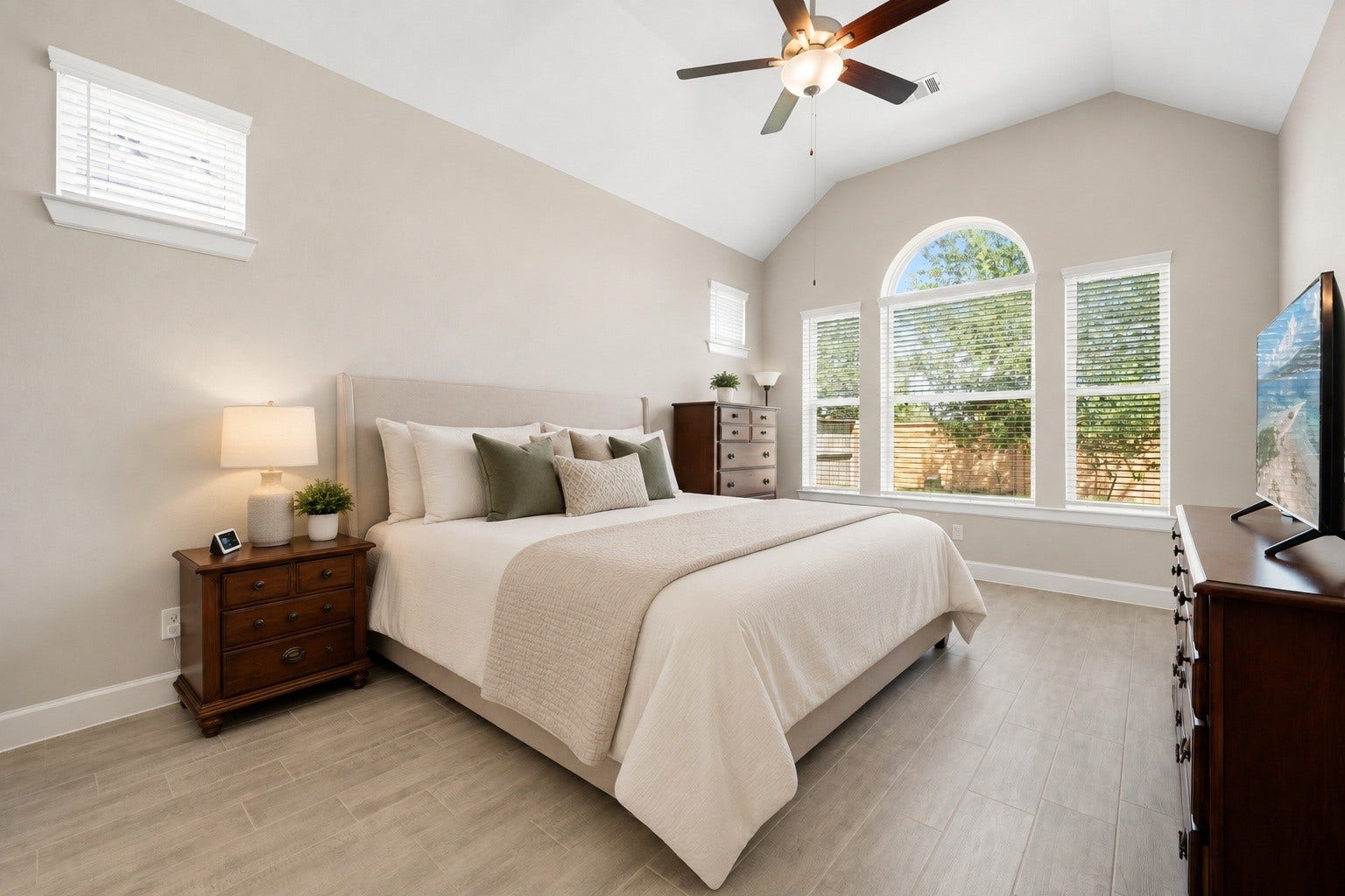 6922 Goldstrum Way, Katy, TX 77493 The primary bedroom offers a vaulted ceiling, a ceiling fan, and an arched window that brings in abundant natural light. Virtually staged.