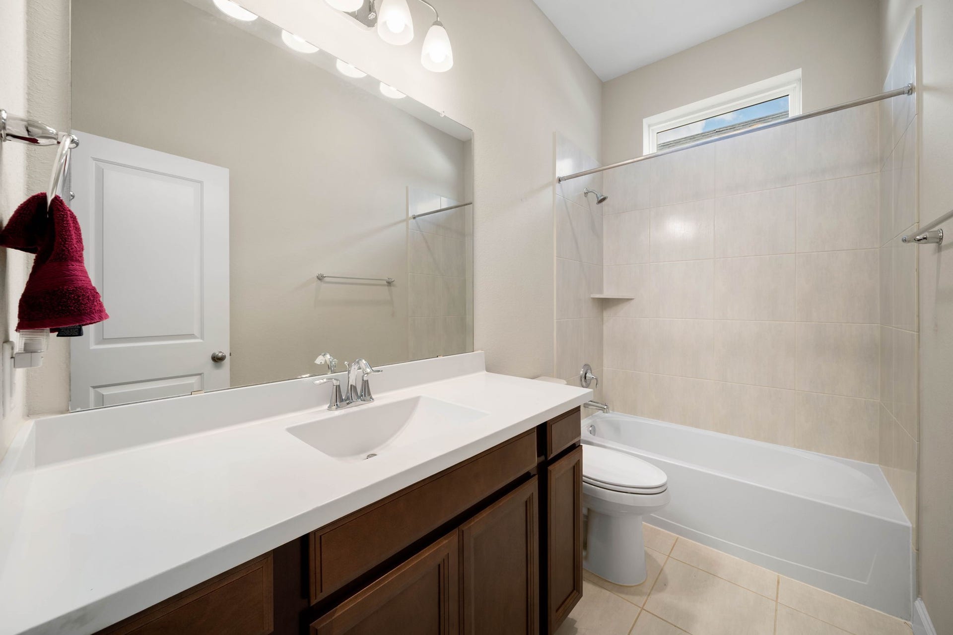 6922 Goldstrum Way, Katy, TX 77493 This secondary bathroom features a single-sink vanity with quartz-look countertop, tile flooring, and a tub/shower combo with tile surround.