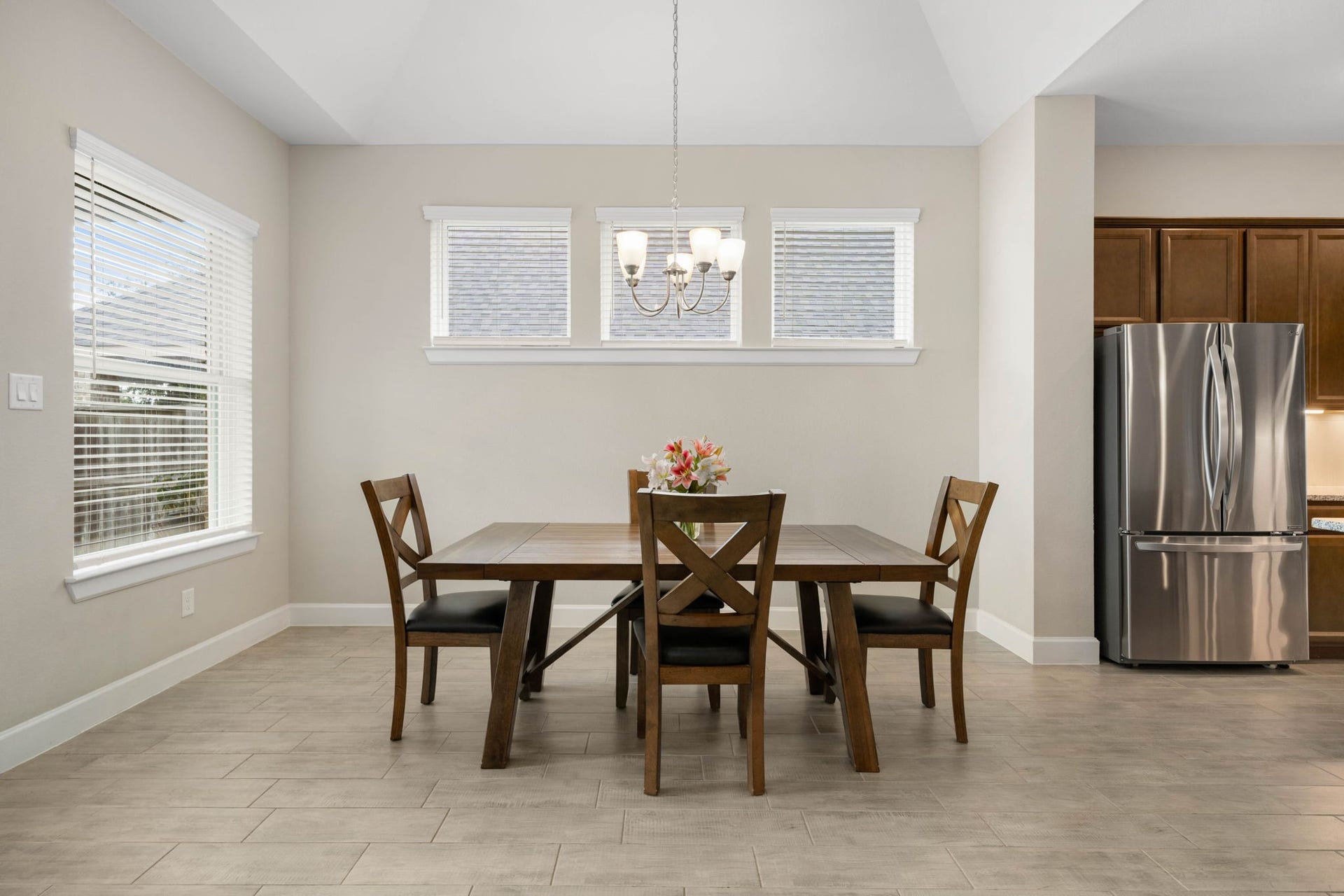 6922 Goldstrum Way, Katy, TX 77493 A bright dining area features a wall of windows and a chandelier, offering a welcoming space for everyday meals or gatherings.