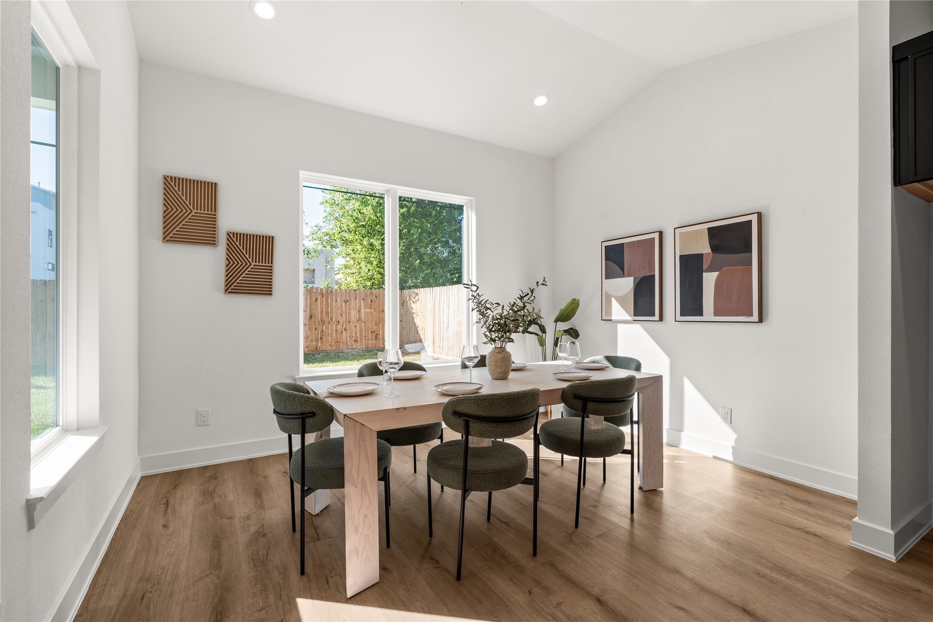 6714 Tierwester Street, Houston, TX 77021 A subtly vaulted ceiling introduces architectural volume to the dining room, creating an airy atmosphere enhanced by expansive windows and abundant natural light.