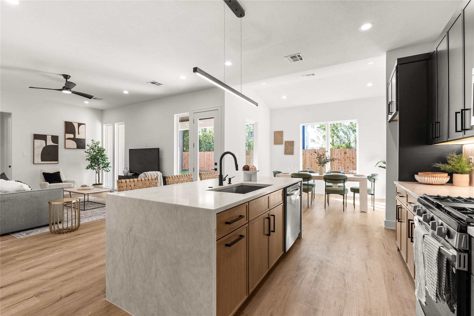 6714 Tierwester Street, Houston, TX 77021 The kitchen's waterfall-edge Quartz Crystallo Lux island serves as a sculptural centerpiece, its softly veined surface cascading to the floor with a seamless, monolithic appearance.