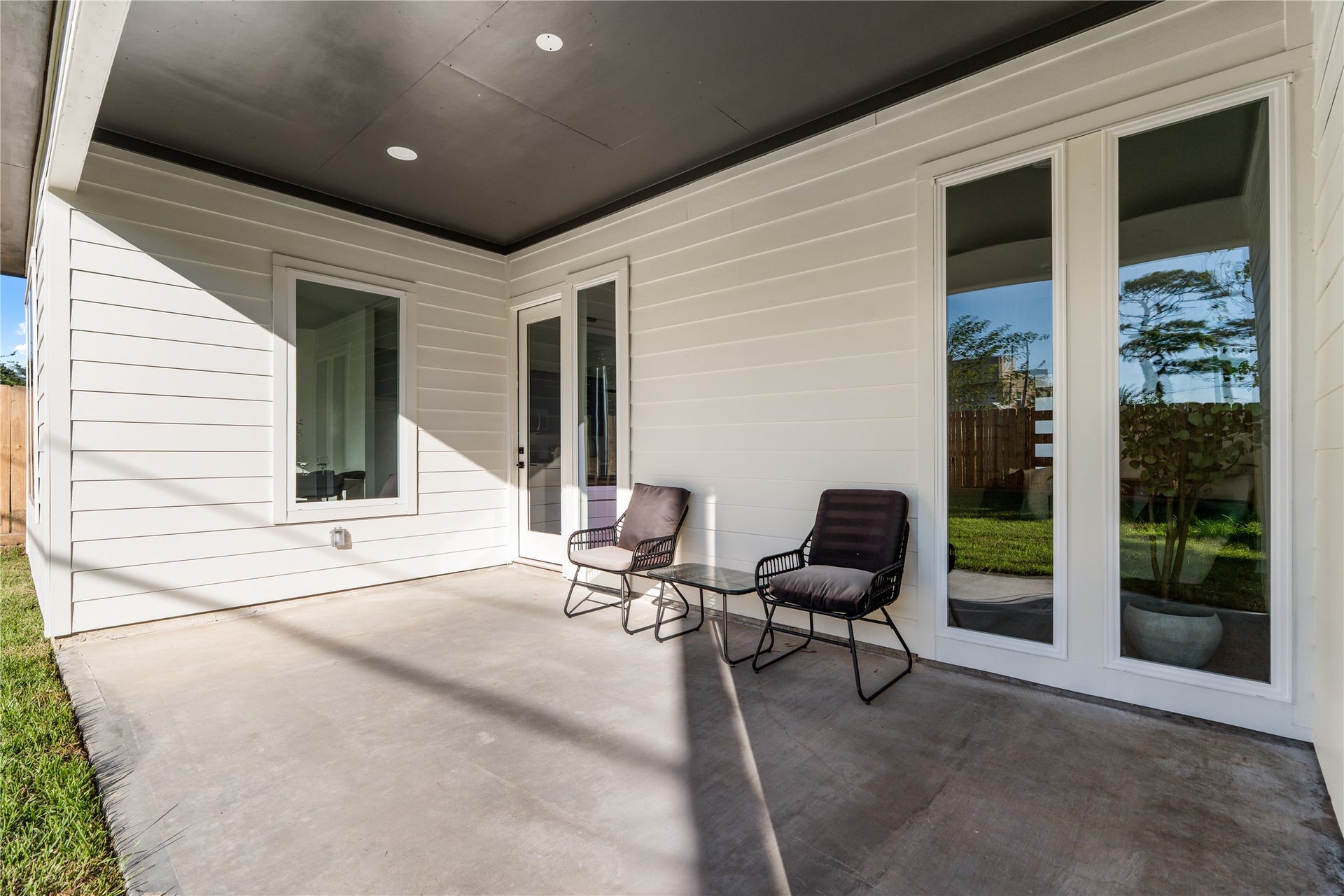 6714 Tierwester Street, Houston, TX 77021 An inviting covered patio with expansive windows and a glass-paneled door create a natural connection between the interior and surrounding backyard.