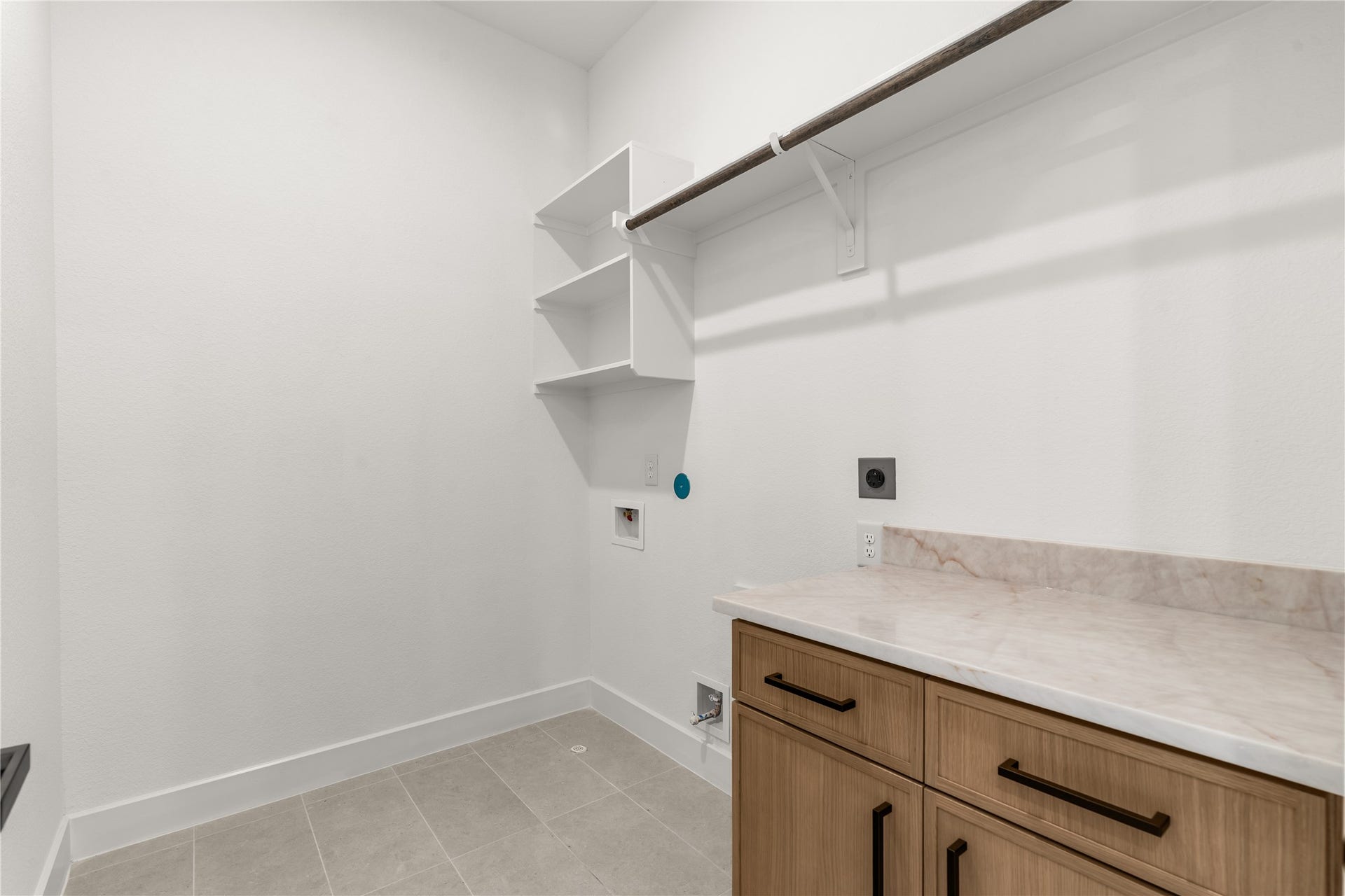 6714 Tierwester Street, Houston, TX 77021 A thoughtfully designed utility room with a generous countertop and open shelving provide an organized setting for laundry and everyday household tasks.