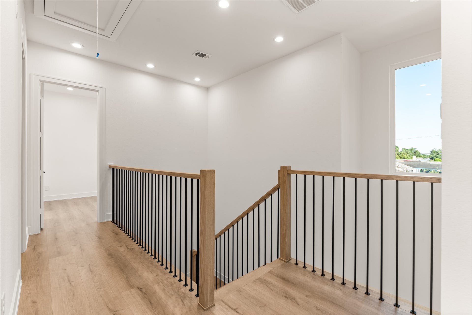 6714 Tierwester Street, Houston, TX 77021 Light LVP flooring extends across the upper landing, while a large window introduces natural light and enhances the home's open, contemporary character.