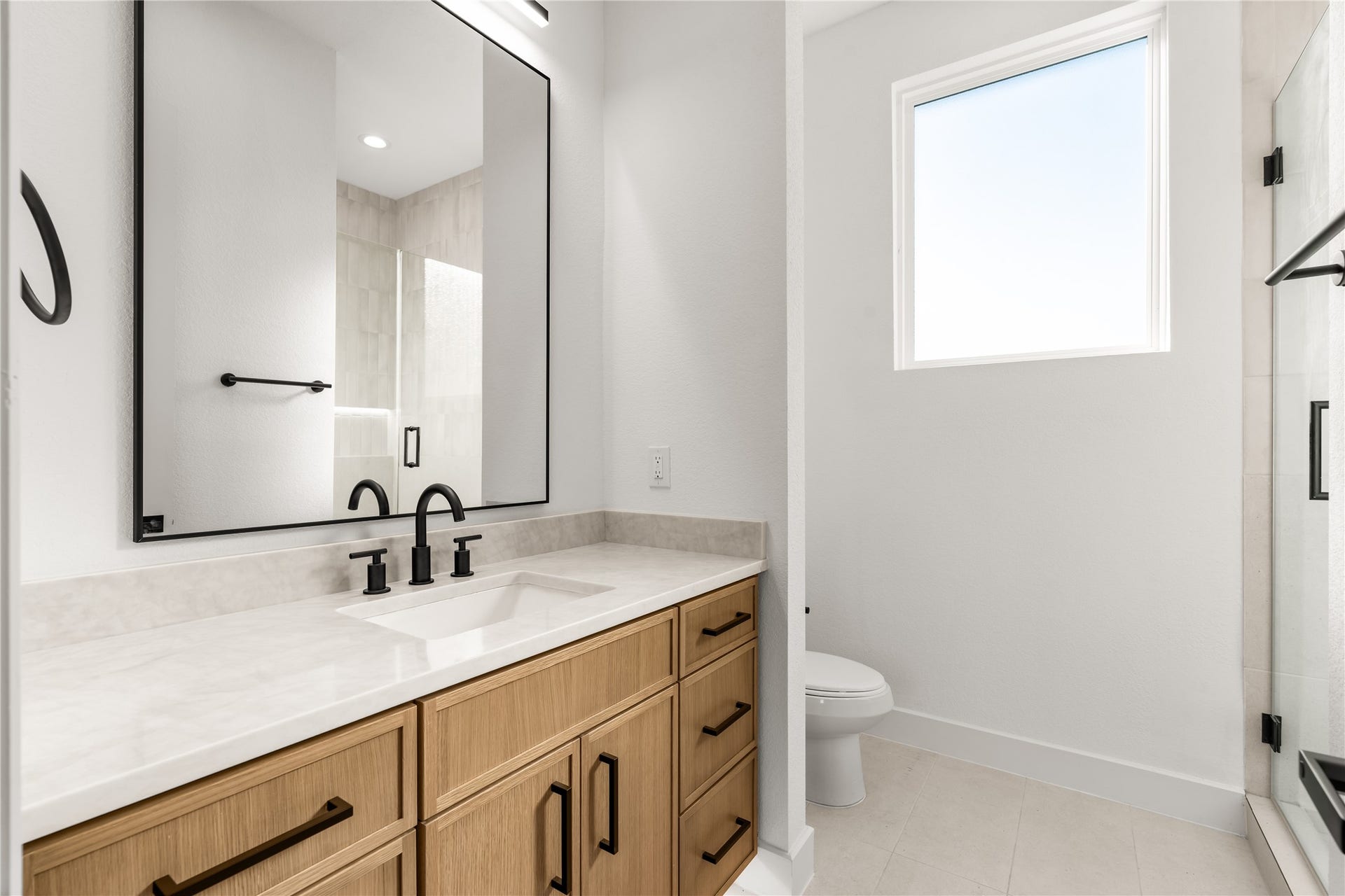 6714 Tierwester Street, Houston, TX 77021 Designed with both practicality and visual appeal in mind, this private en suite features an expansive vanity with ample storage, a glass-enclosed shower, and a contemporary selection of finishes.