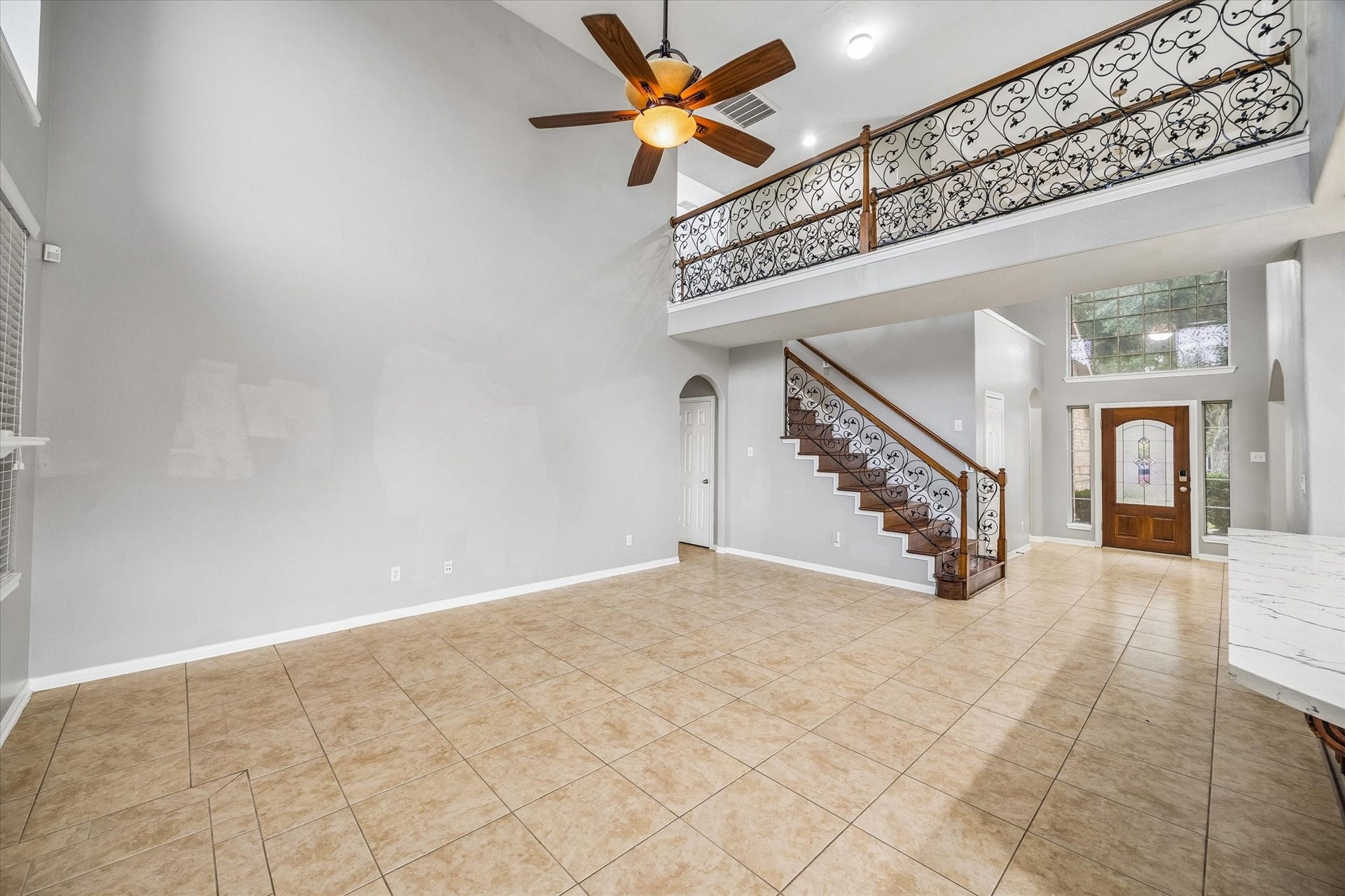 7014 Baristone Lane, Richmond, TX 77407 Soaring ceilings and an elegant staircase with decorative railings create a striking living space.