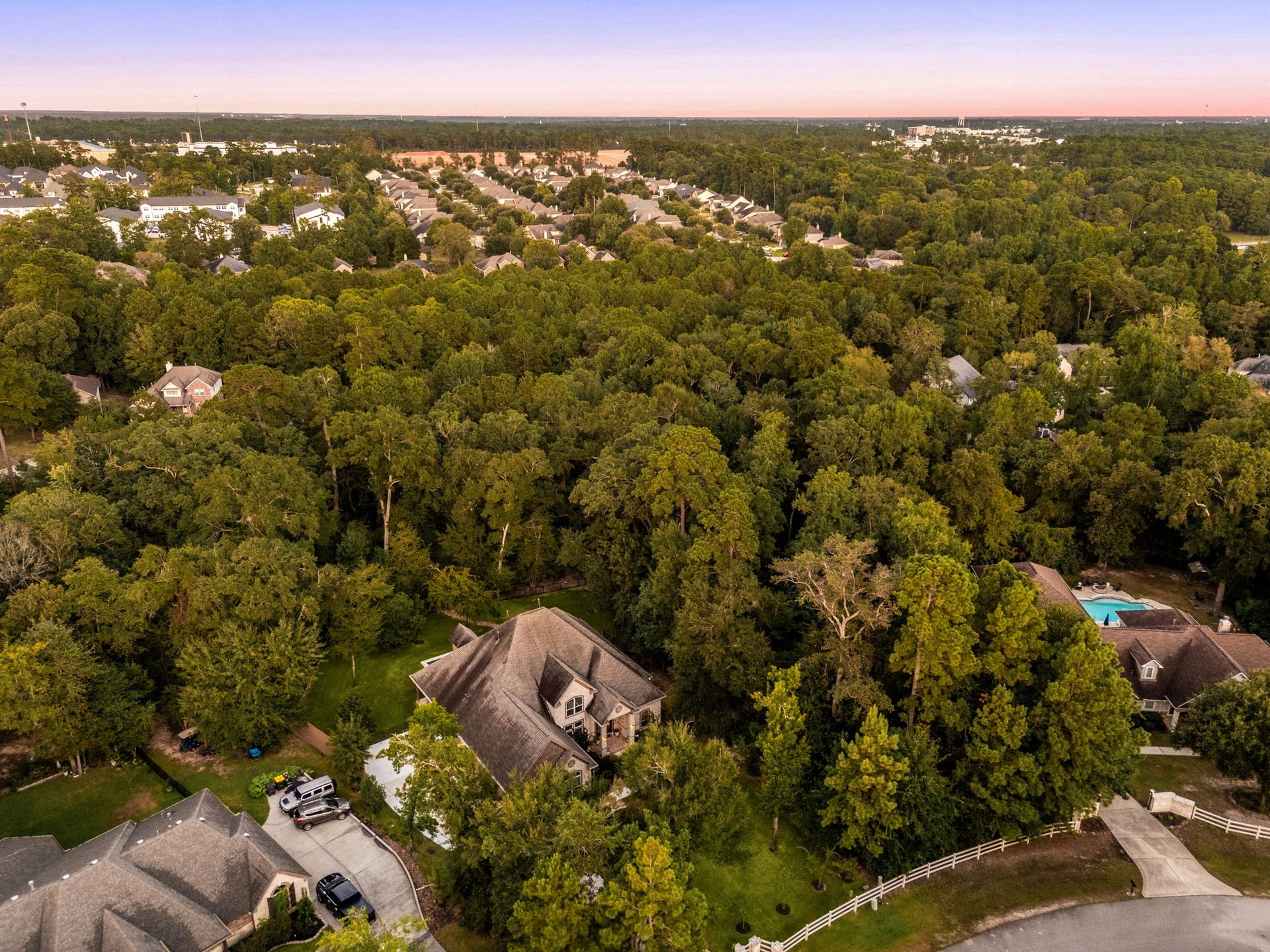 An aerial overview showcases 1904 Boulder Ridge, a stunning property nestled on approximately 1 acre of heavily wooded land. This birds-eye perspective highlights the propertys privacy, natural beauty, and expansive setting, offering a rare opportunity to create your own secluded retreat.