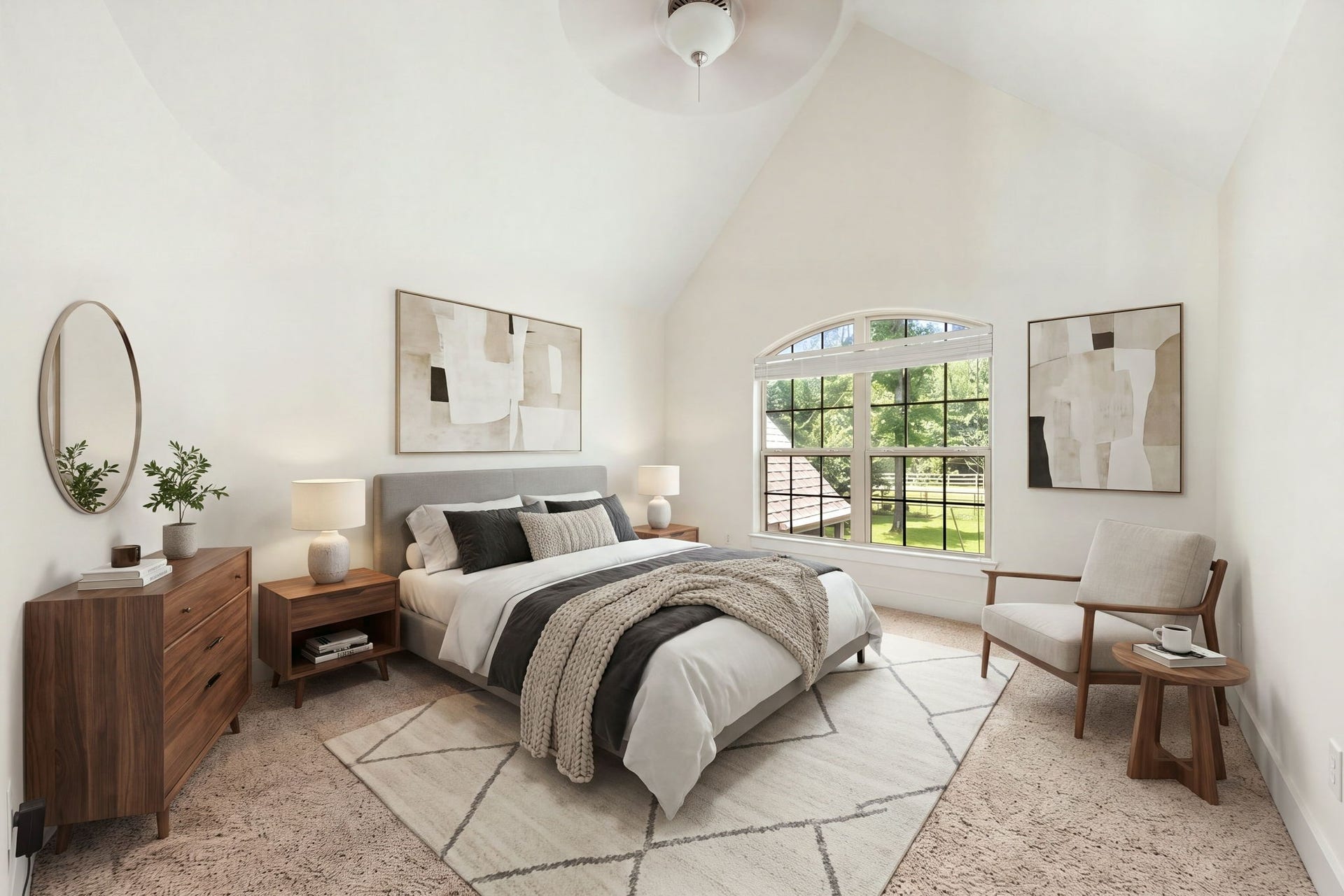 This beautiful secondary bedroom features a towering vaulted ceiling equipped with a central ceiling fan. A large arched window floods the room with beautiful natural light and offers a peaceful view of the outdoors. *Virtually Staged