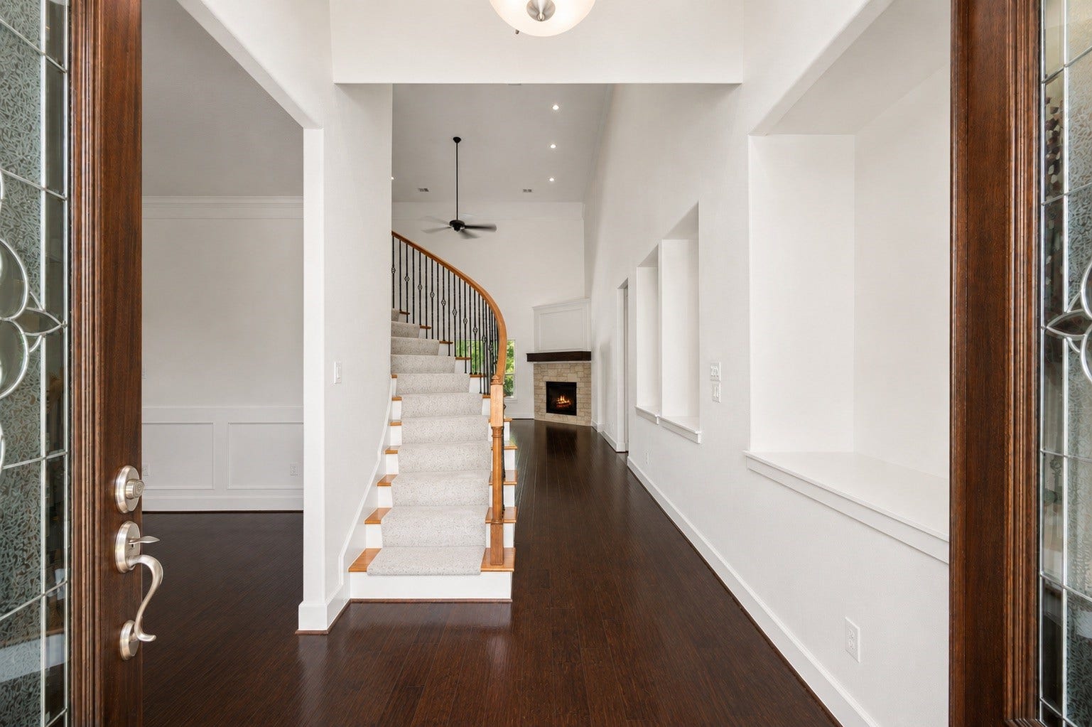 Step through the gorgeous double doors into a breathtaking foyer! This dramatic entryway boasts rich hardwood floors, towering high ceilings, and a sweeping curved staircase that immediately sets a luxurious tone for the rest of the home.