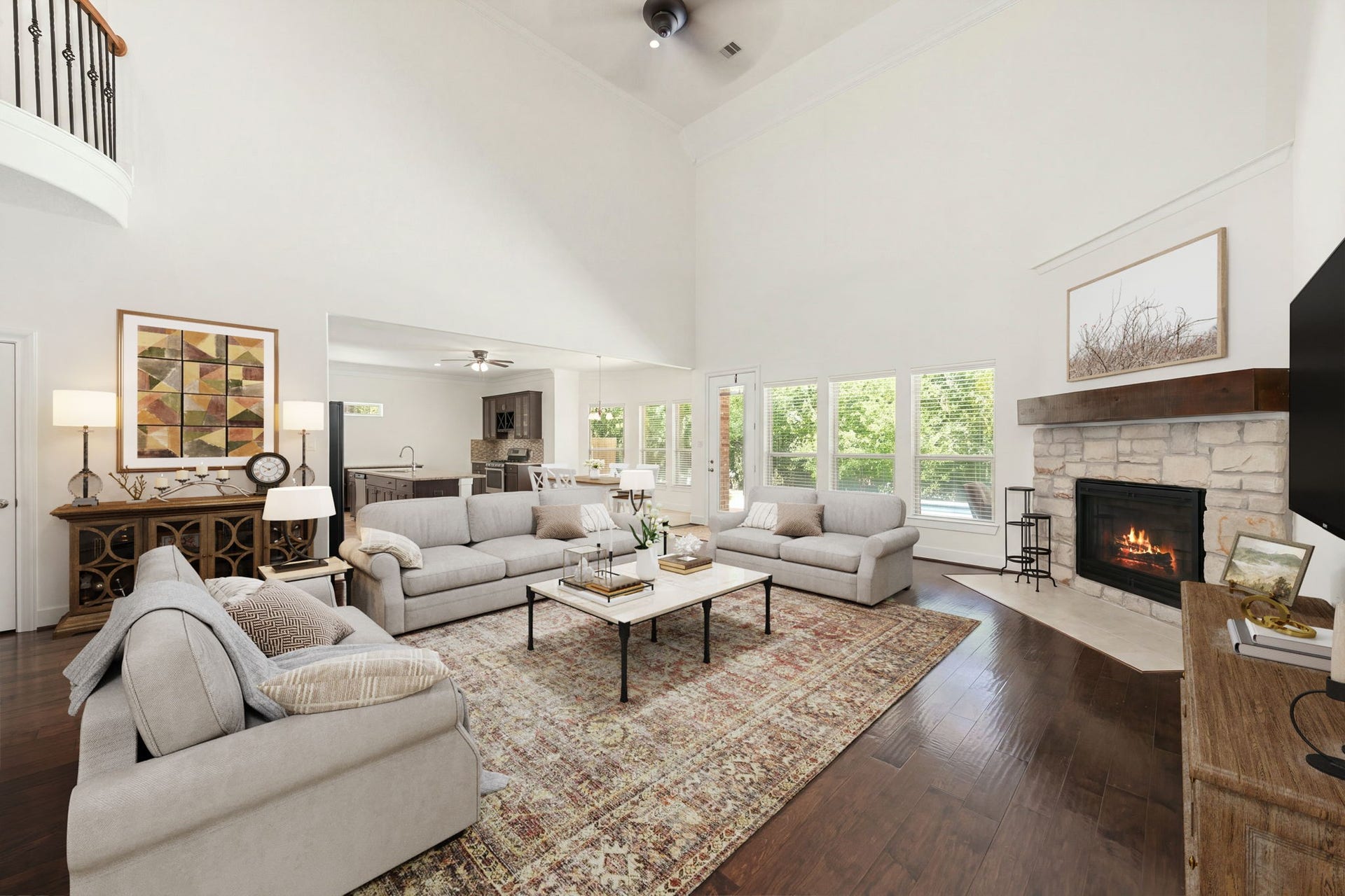 This spacious family room features a stone fireplace with a rustic wooden mantel as its central focal point. A large bank of windows floods the entire area with bright, natural light while offering scenic views of the backyard. *Virtually Staged