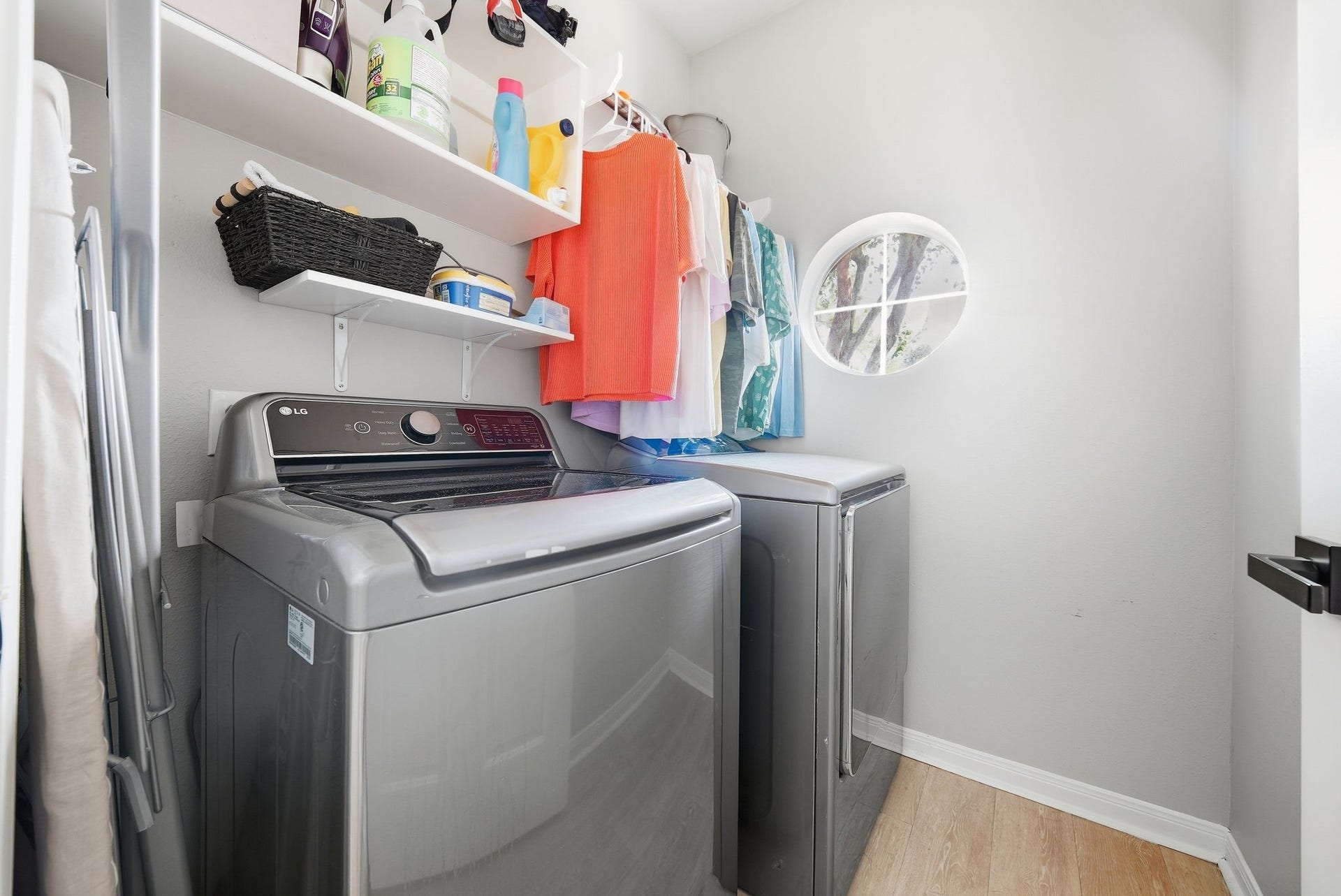 402 Prattwood Court, League City, TX 77573 Convenient laundry room with a washer and dryer, built-in shelving, hanging space, and a round window for natural light.