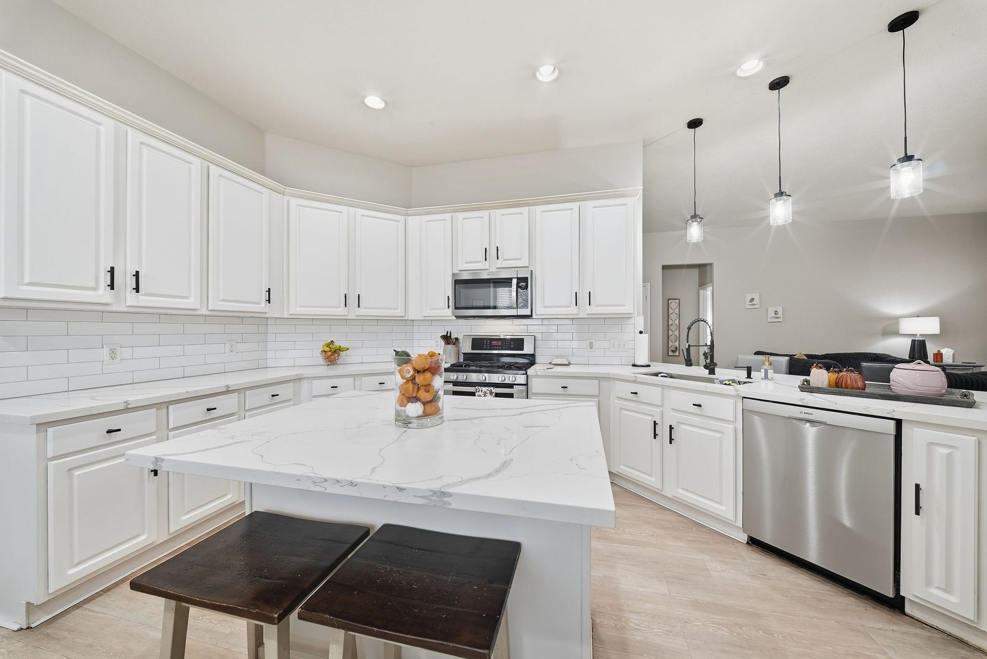 402 Prattwood Court, League City, TX 77573 Spacious kitchen featuring white cabinetry, quartz countertops, large center island, stainless steel appliances, and pendant lighting.
