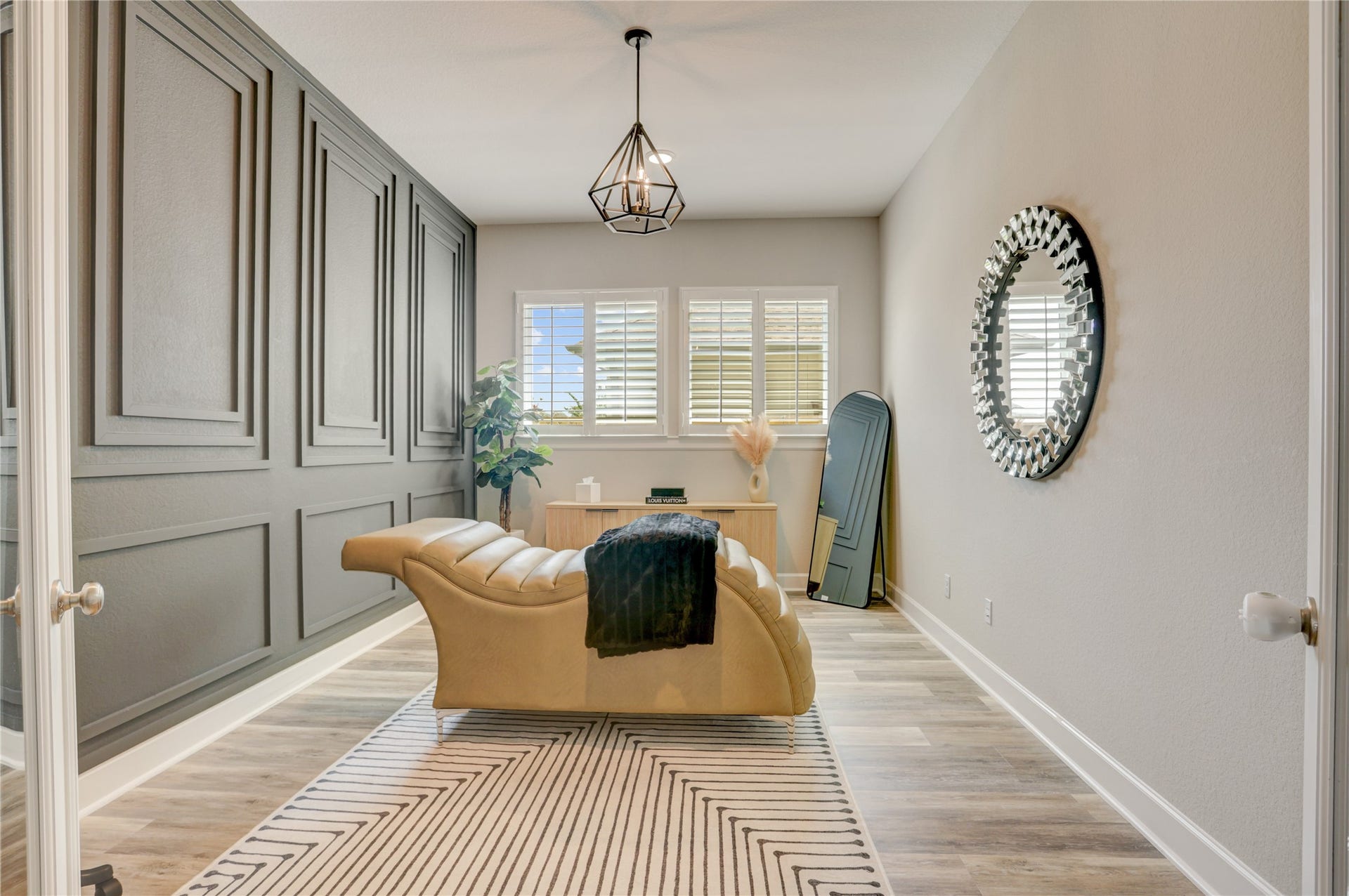 10615 Parkwood Court, Missouri City, TX 77459 Sophisticated home office featuring a custom designer accent wall, elegant plantation shutters, and a statement chandelier that elevates the space with modern character and style.