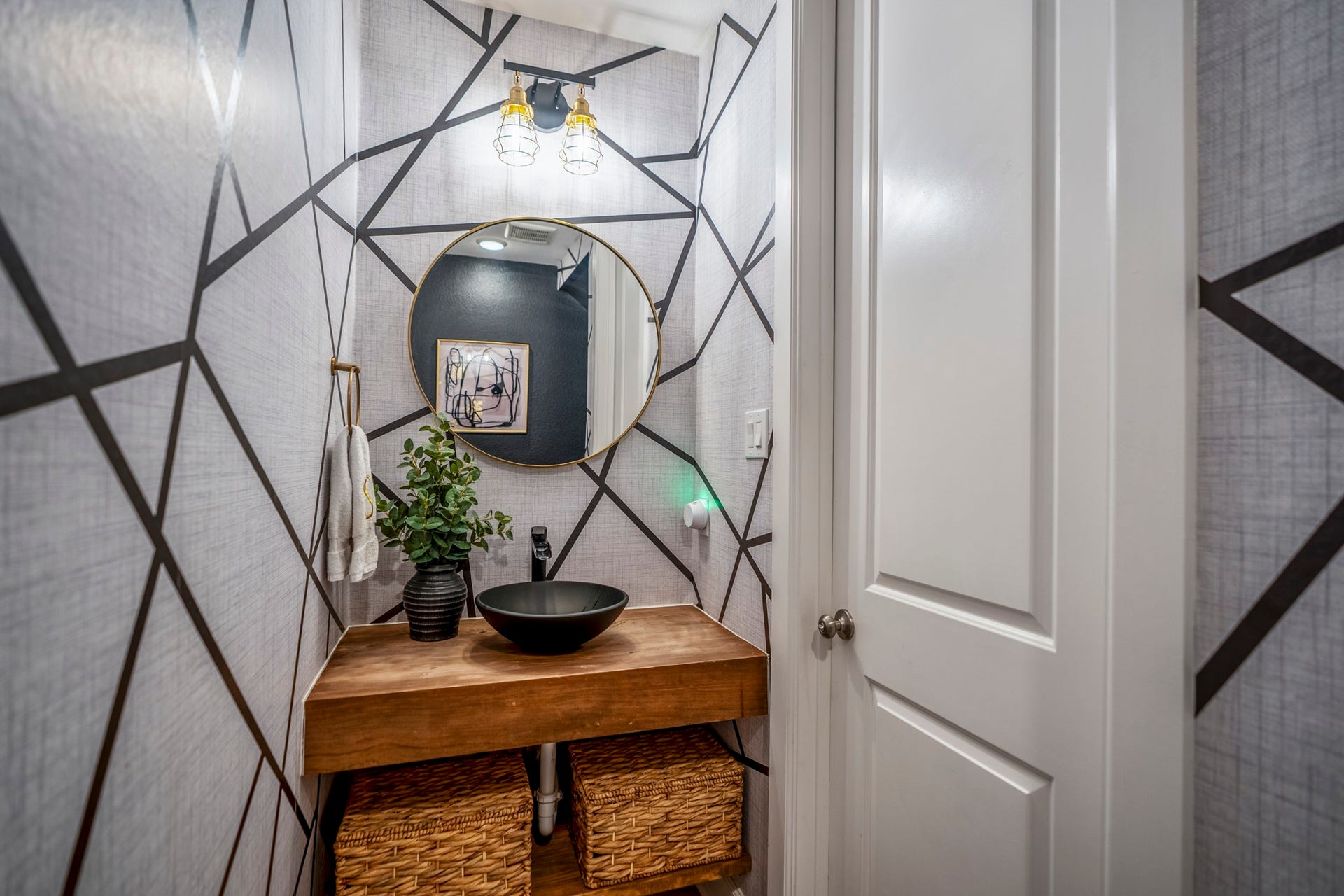 10615 Parkwood Court, Missouri City, TX 77459 Designer powder bath featuring bold geometric wallpaper, a custom floating wood vanity, and a striking vessel sink that adds a modern luxury touch. Thoughtfully curated finishes and statement lighting create a sophisticated space full of character and style.