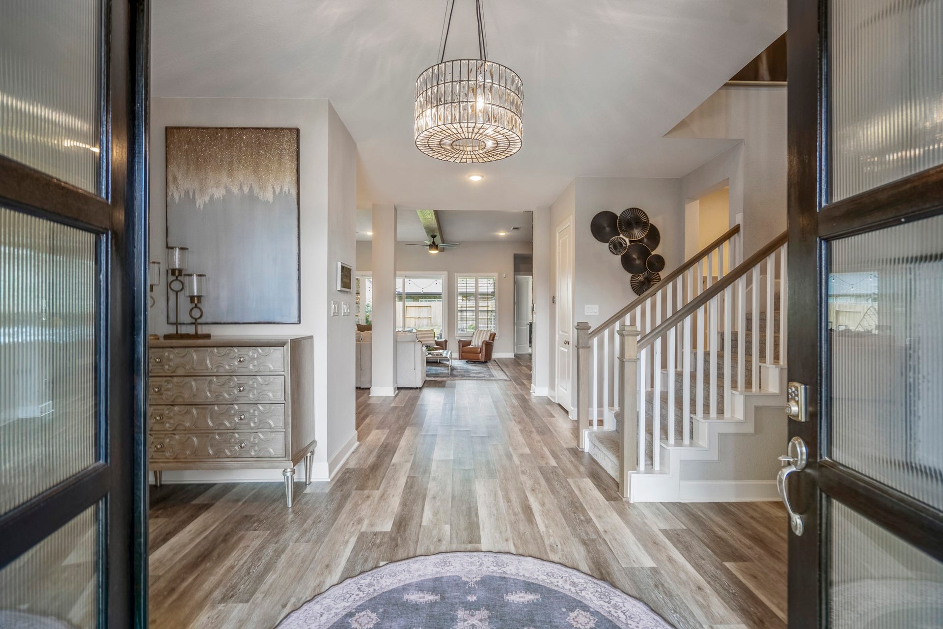 10615 Parkwood Court, Missouri City, TX 77459 Grand entry with a beautiful statement chandelier, luxury vinyl plank flooring, and an open view into the main living areas. The bright, welcoming layout and elegant staircase create a warm first impression the moment you walk through the door.