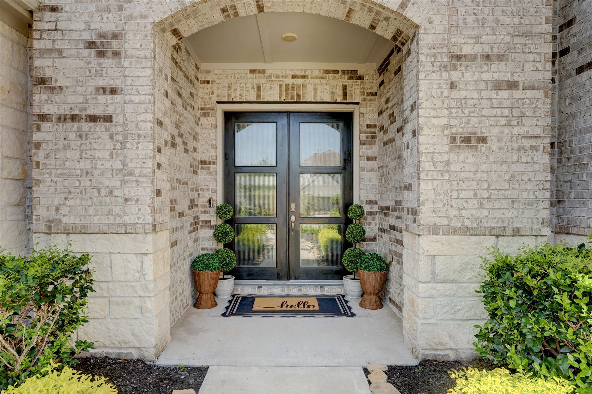 10615 Parkwood Court, Missouri City, TX 77459 Covered front porch with an arched entry and double front doors that create a warm, inviting first impression. The brick and stone exterior adds timeless character while the covered entry provides both charm and functionality.