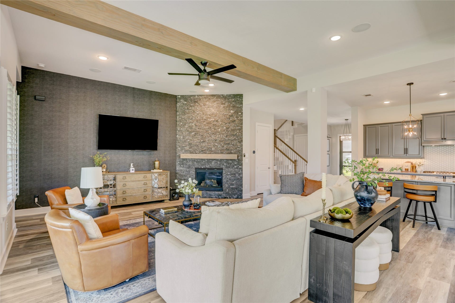 10615 Parkwood Court, Missouri City, TX 77459 The open concept family room features striking wood beams, a floor-to-ceiling stone fireplace, and a seamless connection to the kitchen, creating an inviting space for everyday living and entertaining.