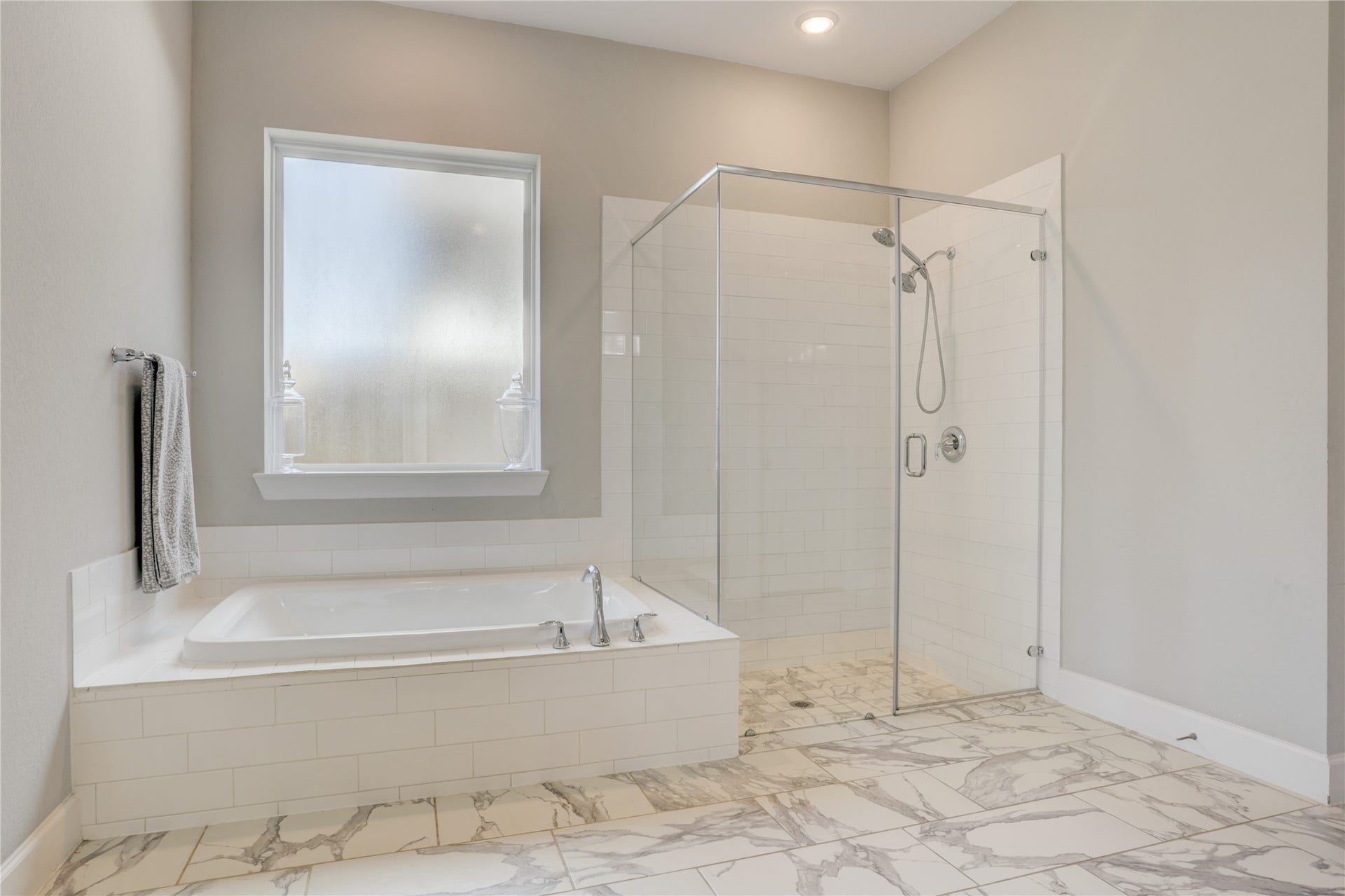 10615 Parkwood Court, Missouri City, TX 77459 Elegant spa-inspired primary bath featuring a soaking tub, oversized frameless glass shower, and stunning marble-look tile flooring throughout. Clean lines, timeless finishes, and a spacious layout create a luxurious retreat designed for relaxation and everyday comfort.