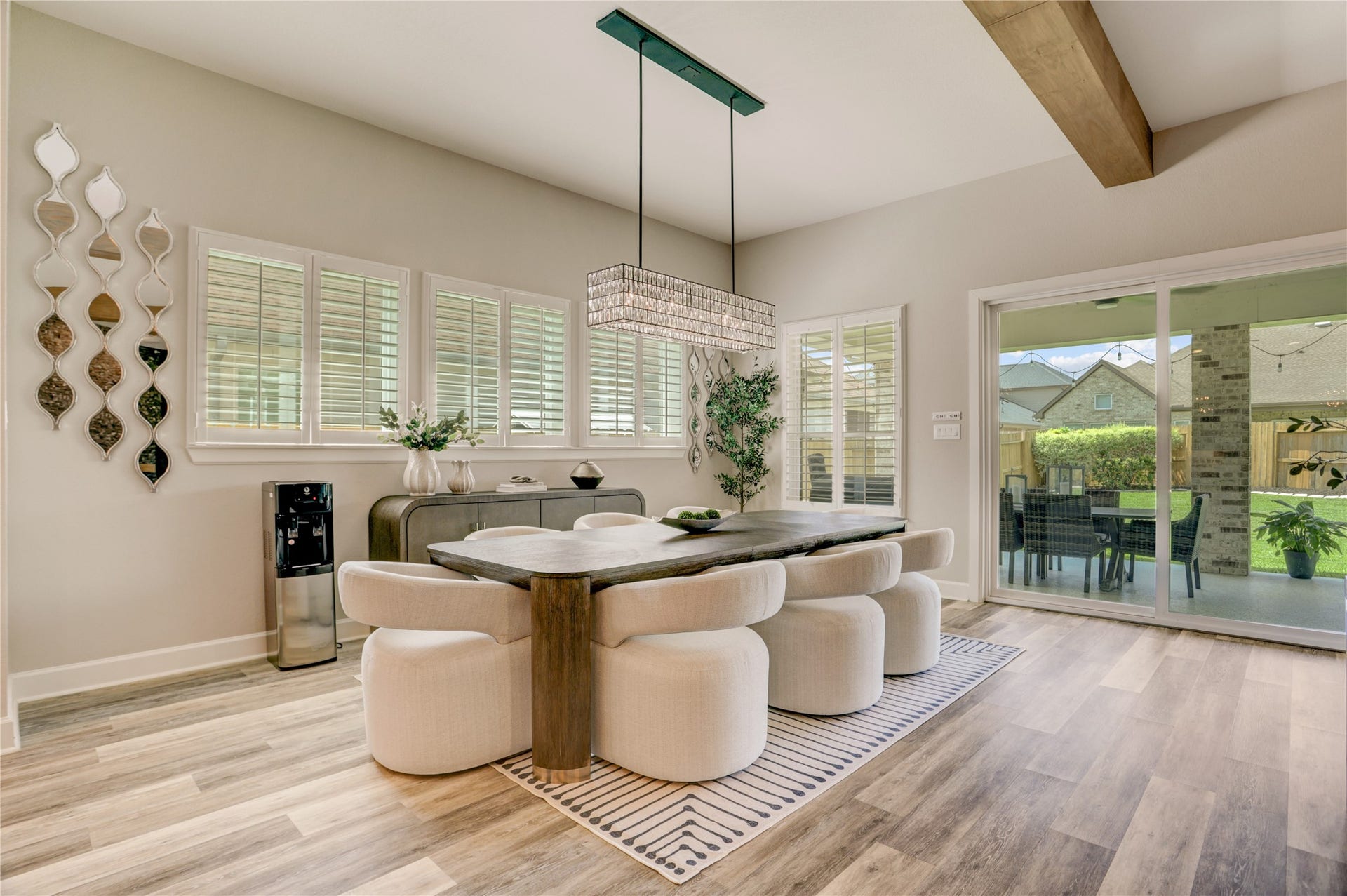 10615 Parkwood Court, Missouri City, TX 77459 Elegant dining area illuminated by a stunning statement chandelier and surrounded by expansive windows that fill the space with beautiful natural light. Perfectly positioned overlooking the backyard and covered patio, this inviting space creates an ideal atmosphere for both intimate dinners and entertaining guests.