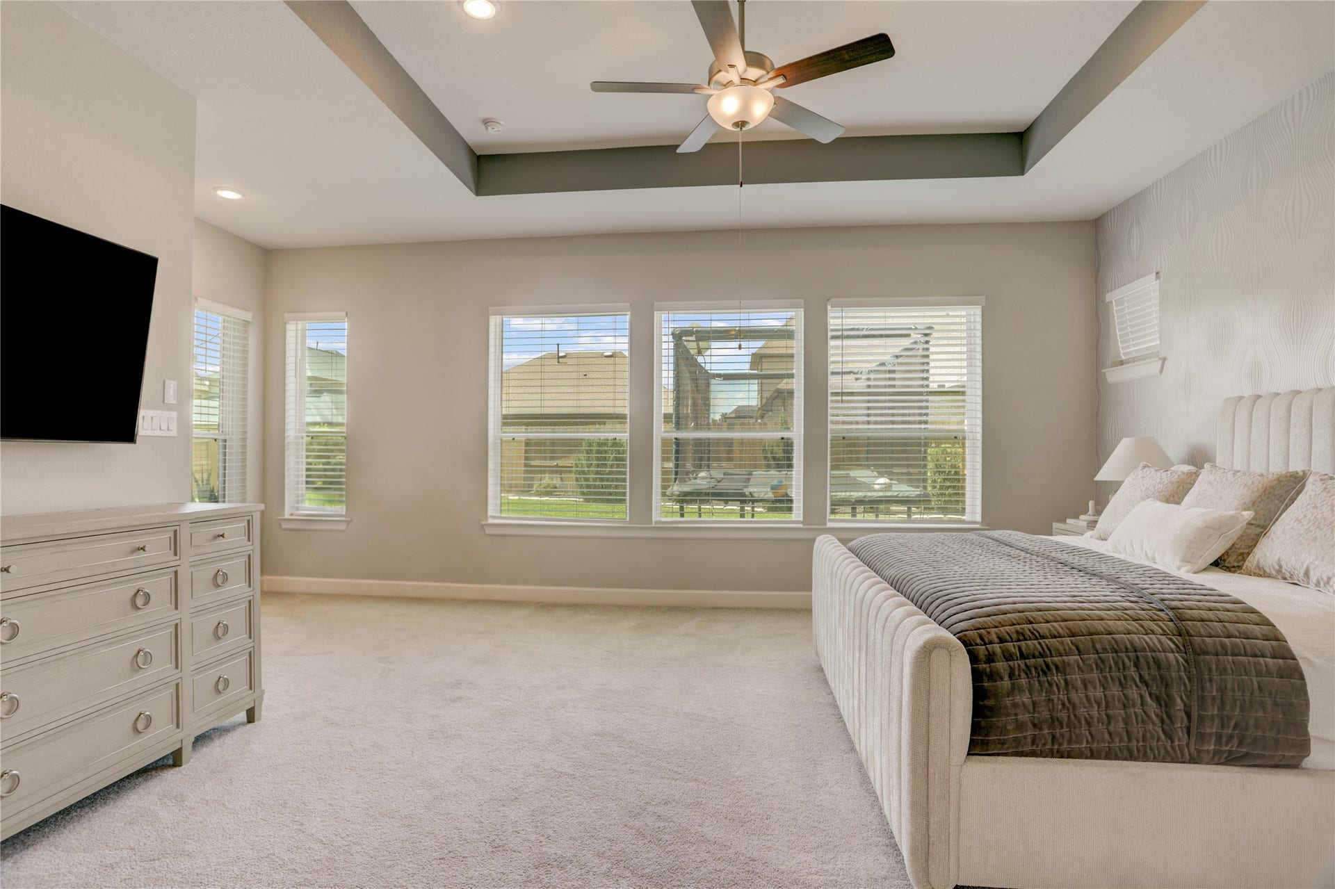 10615 Parkwood Court, Missouri City, TX 77459 Expansive primary suite offering a spacious and serene retreat, complete with plush carpeting, elevated tray ceilings, and custom barn doors leading into the spa-inspired primary bath. The oversized layout provides ample room for both relaxation and everyday comfort while maintaining a refined luxury feel.