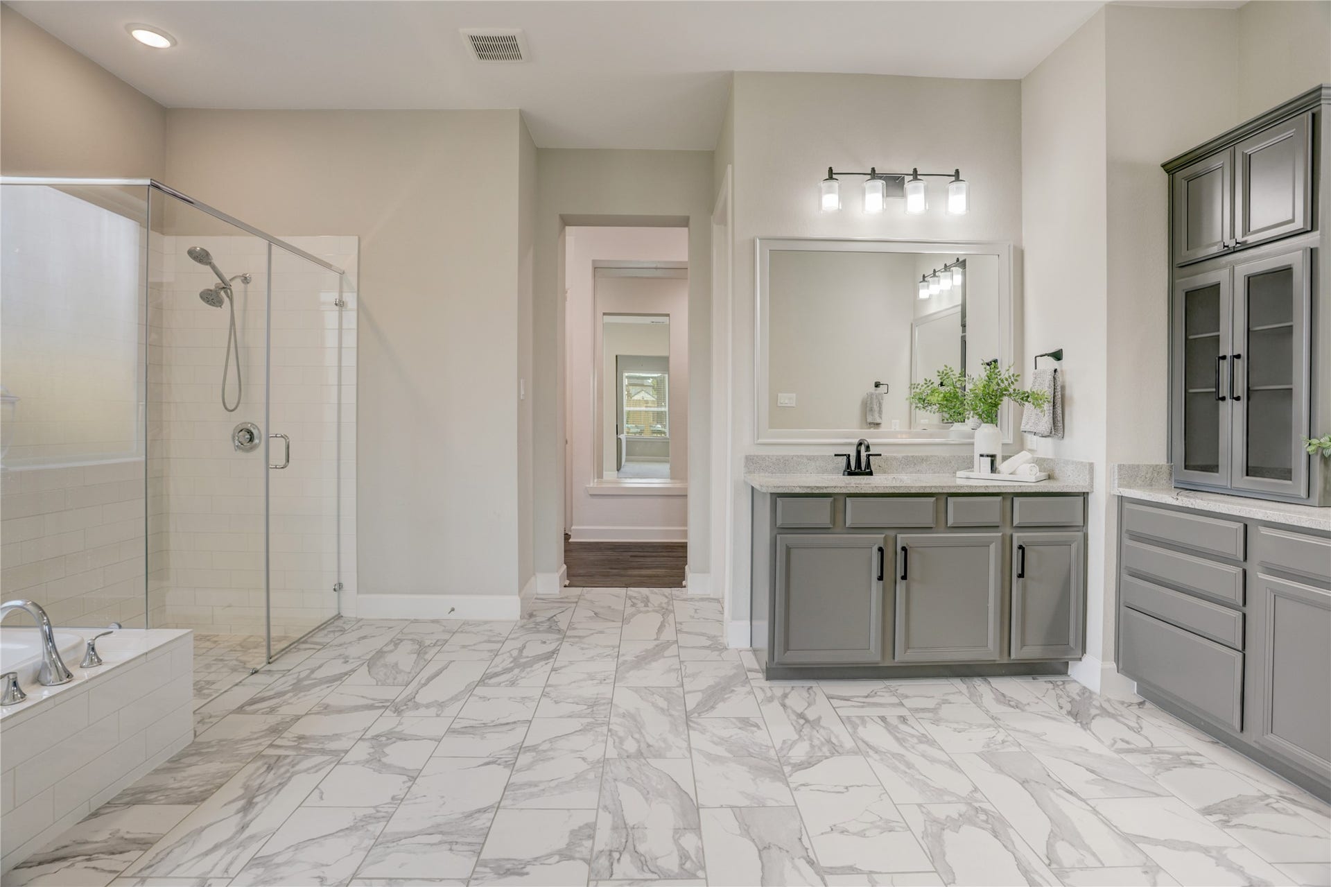 10615 Parkwood Court, Missouri City, TX 77459 Primary bath designed with a seamless open flow into the expansive walk-in closet, creating a true retreat feel. Featuring elegant finishes, oversized vanity space, sleek frameless shower detailing, and striking tile work that brings a sophisticated spa-like atmosphere.