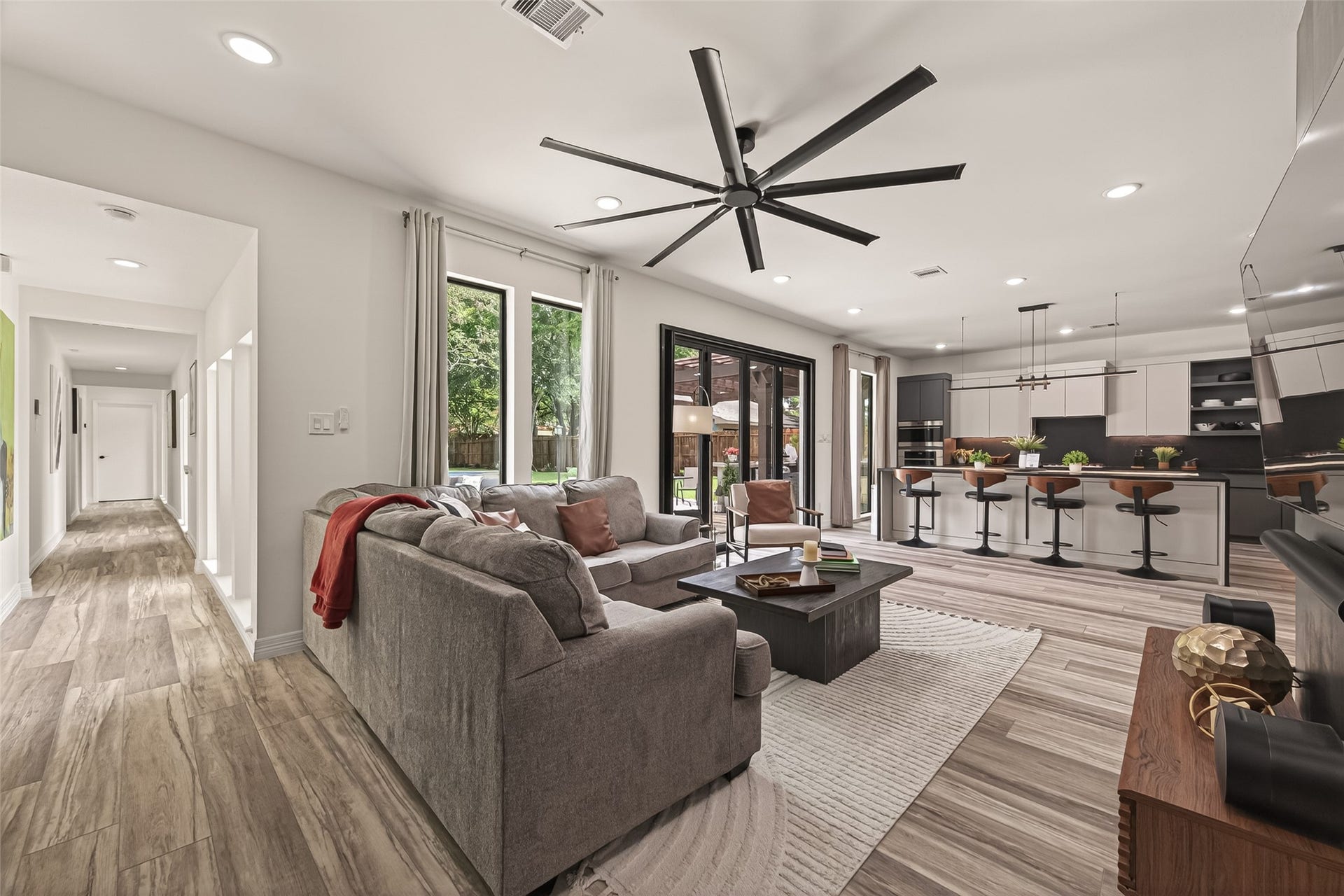 5422 Valerie Street, Bellaire, TX 77401 This contemporary open-concept living space is filled with abundant natural light streaming through multiple large windows, creating a bright and welcoming atmosphere throughout the main living area.