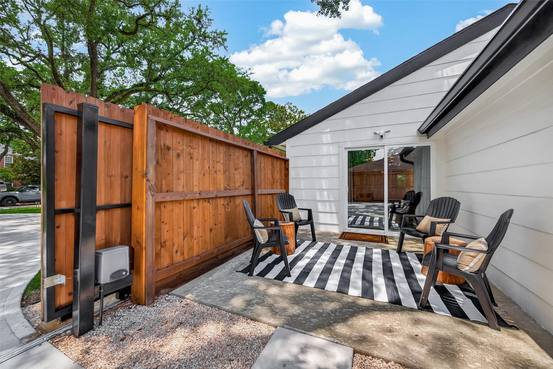 5422 Valerie Street, Bellaire, TX 77401 Cozy outdoor patio area framed by a wood privacy fence, creating a quiet and inviting retreat perfect for morning coffee or evening relaxation. A comfortable, private space that extends the home outdoors and offers a peaceful spot to unwind or entertain. Located off the living area is a perfect hide out. Auto driveway gate and new fence too.