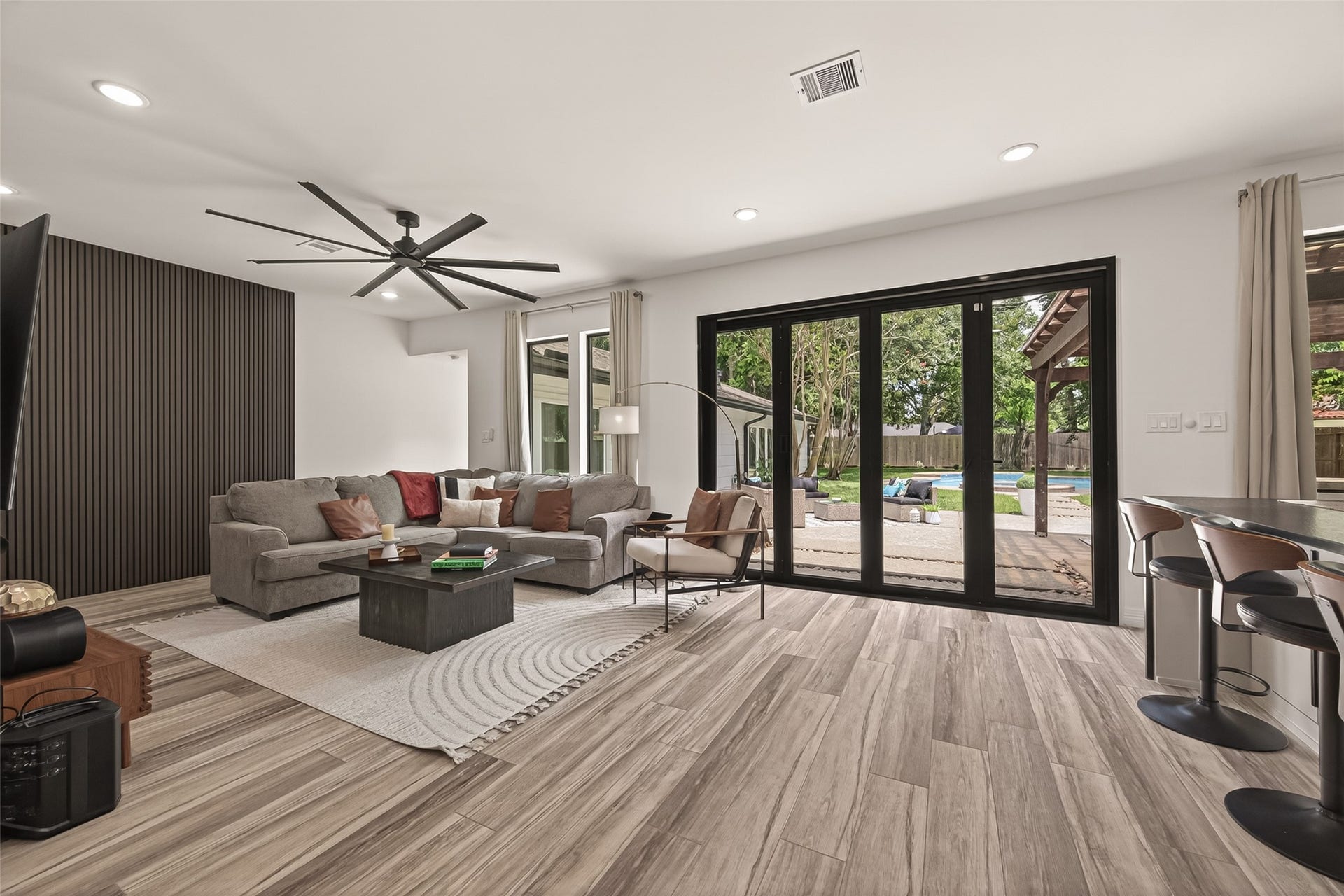 5422 Valerie Street, Bellaire, TX 77401 The living room offers a warm, inviting space at the heart of the home, seamlessly connected to the kitchen and dining areas. Recently installed floor-to-ceiling windows/bifold doors create a stunning wall of glass, filling the space with natural light and beautifully connecting the family room to the patio and outdoor kitchen. Designed for both relaxation and entertaining, this open-concept layout makes it easy to unwind, gather with guests, and enjoy effortless indoor-outdoor living.