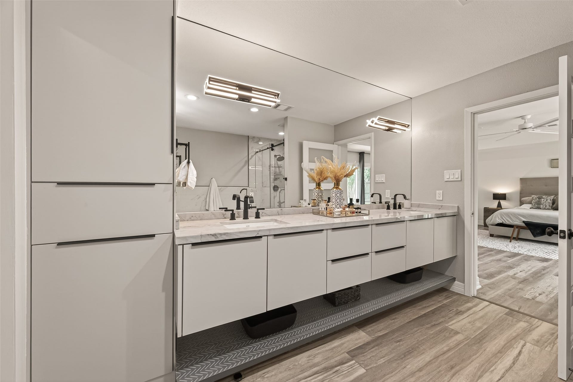 5422 Valerie Street, Bellaire, TX 77401 Primary bathroom featuring a refined, modern design with dual vanities, generous countertop space, and an oversized mirror that enhances the light and open feel. Clean lines and well-appointed finishes create a comfortable, spa-like retreat ideal for everyday function and design.