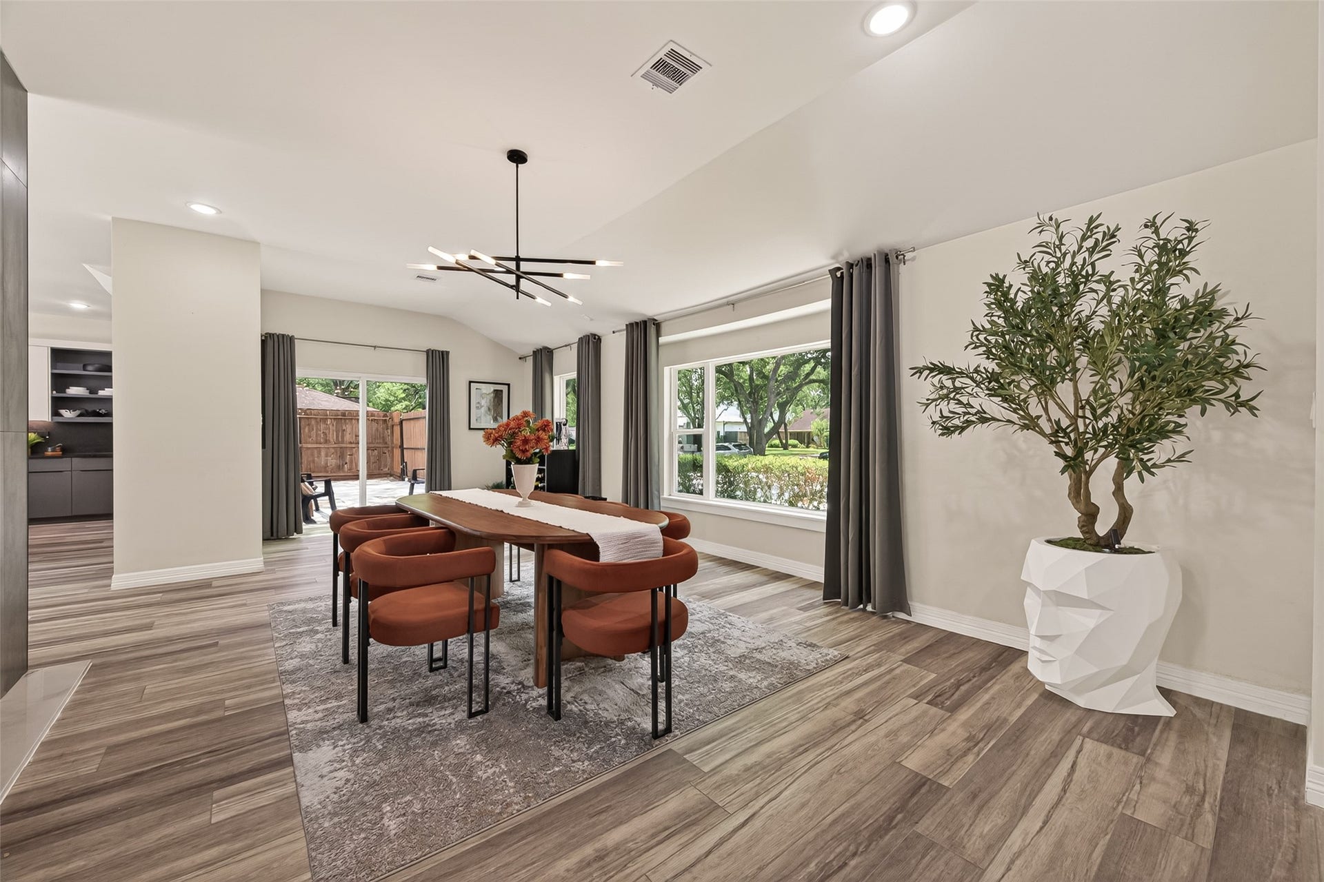 5422 Valerie Street, Bellaire, TX 77401 This modern dining area features sleek wood flooring, a stylish chandelier, and large windows.