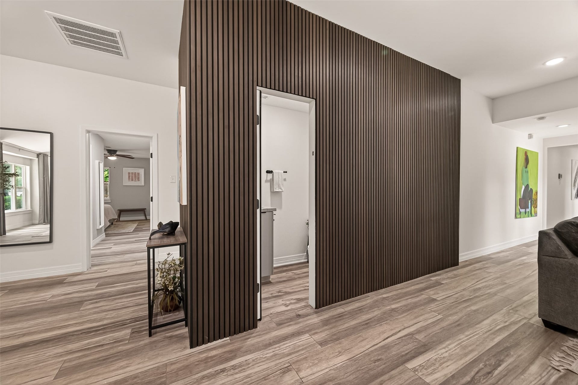 5422 Valerie Street, Bellaire, TX 77401 This elegant wall section serves as a refined architectural divider, subtly defining the homes living spaces while maintaining an open, cohesive flow. A discreetly positioned half bath is located just beyond the opening.