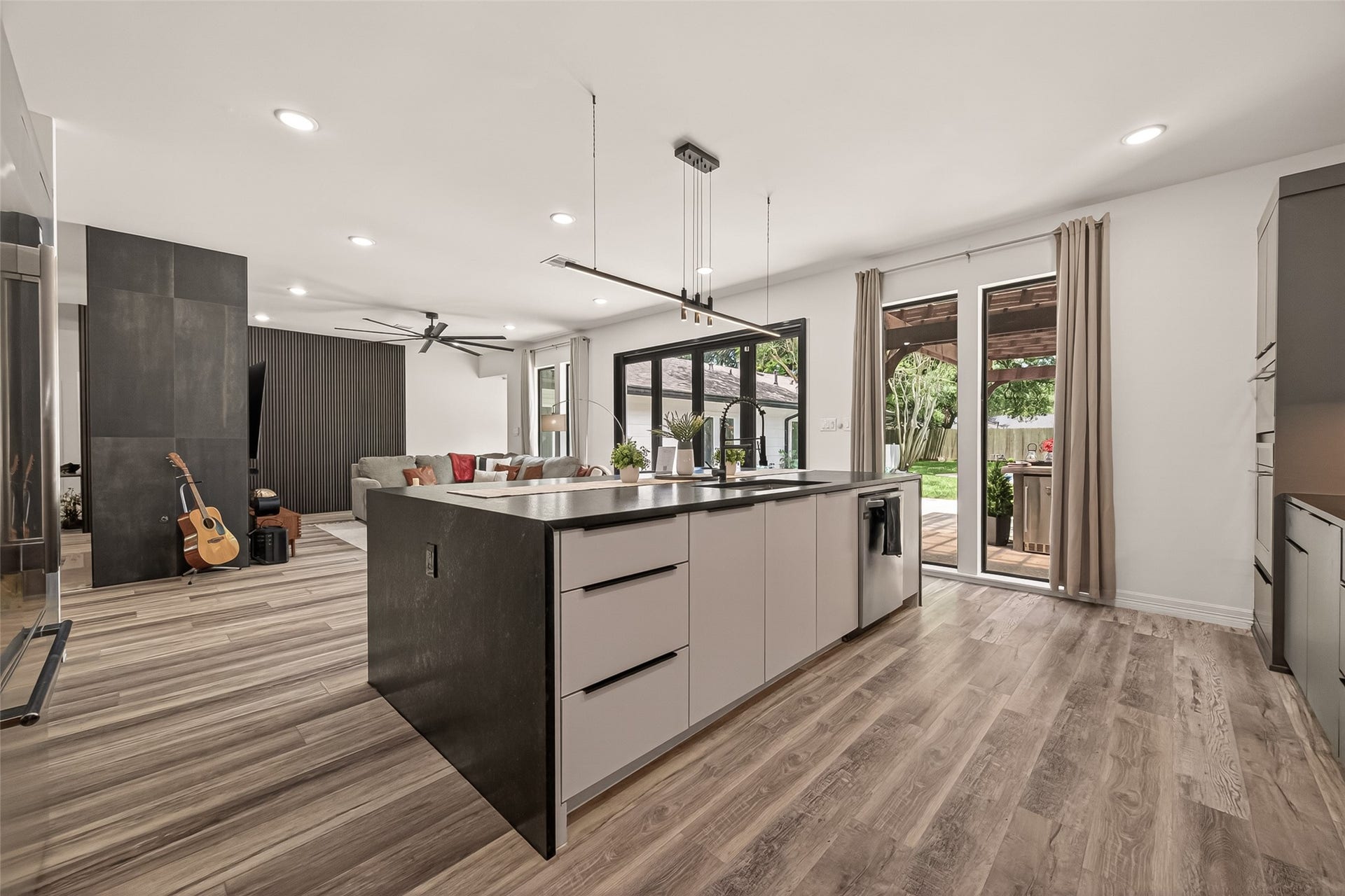 5422 Valerie Street, Bellaire, TX 77401 The kitchen island serves as a central gathering point within the open-concept layout, seamlessly flow into the main living space. Large windows and glass doors invite abundant natural light, creating a bright, airy atmosphere