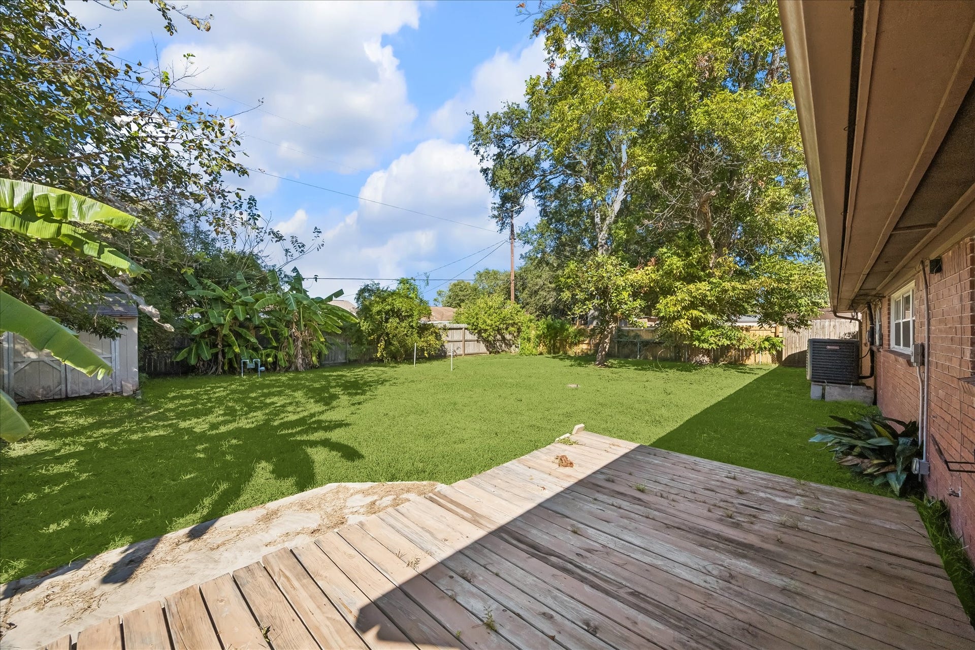 7824 Yucca Drive, Texas City, TX 77591 Wood deck overlooking the backyard with a storage shed.