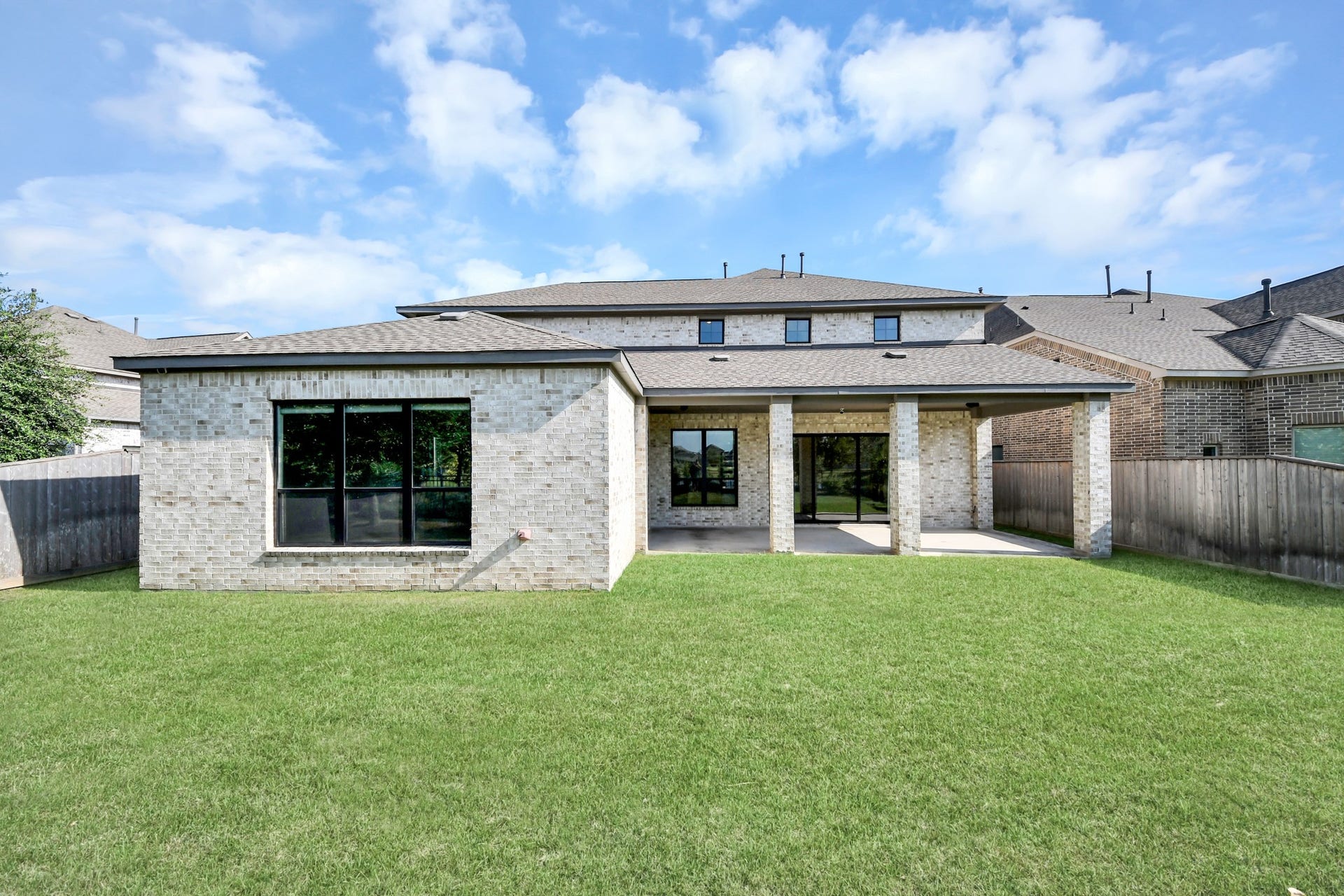 1423 Hackberry Heights Drive, Richmond, TX 77406 Spacious backyard with a covered patio area, ideal for outdoor relaxation and entertainment, complemented by a modern brick exterior.