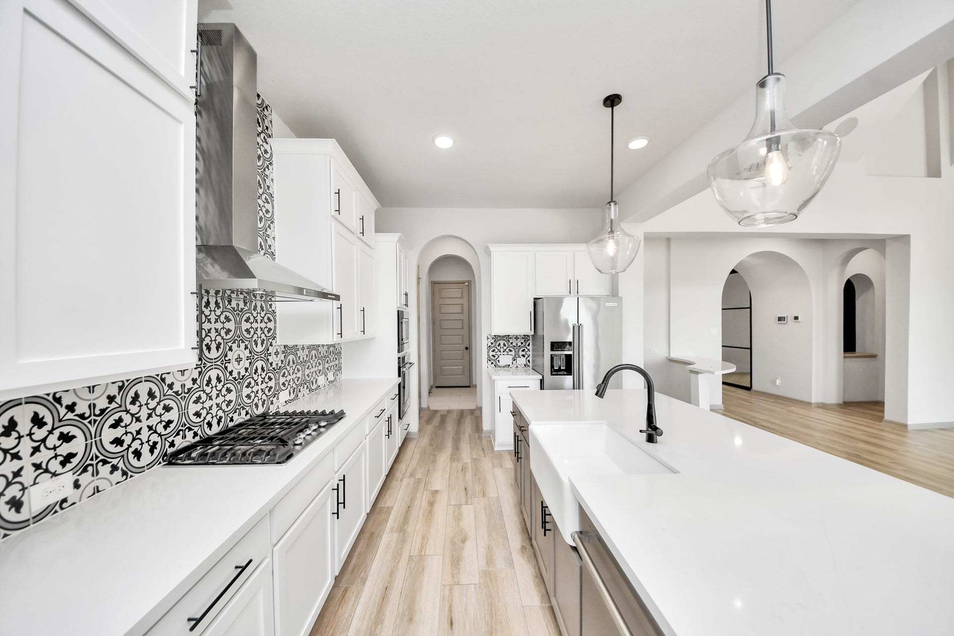 1423 Hackberry Heights Drive, Richmond, TX 77406 Sleek and modern kitchen featuring elegant pendant lighting, and stylish black and white tile backsplash.