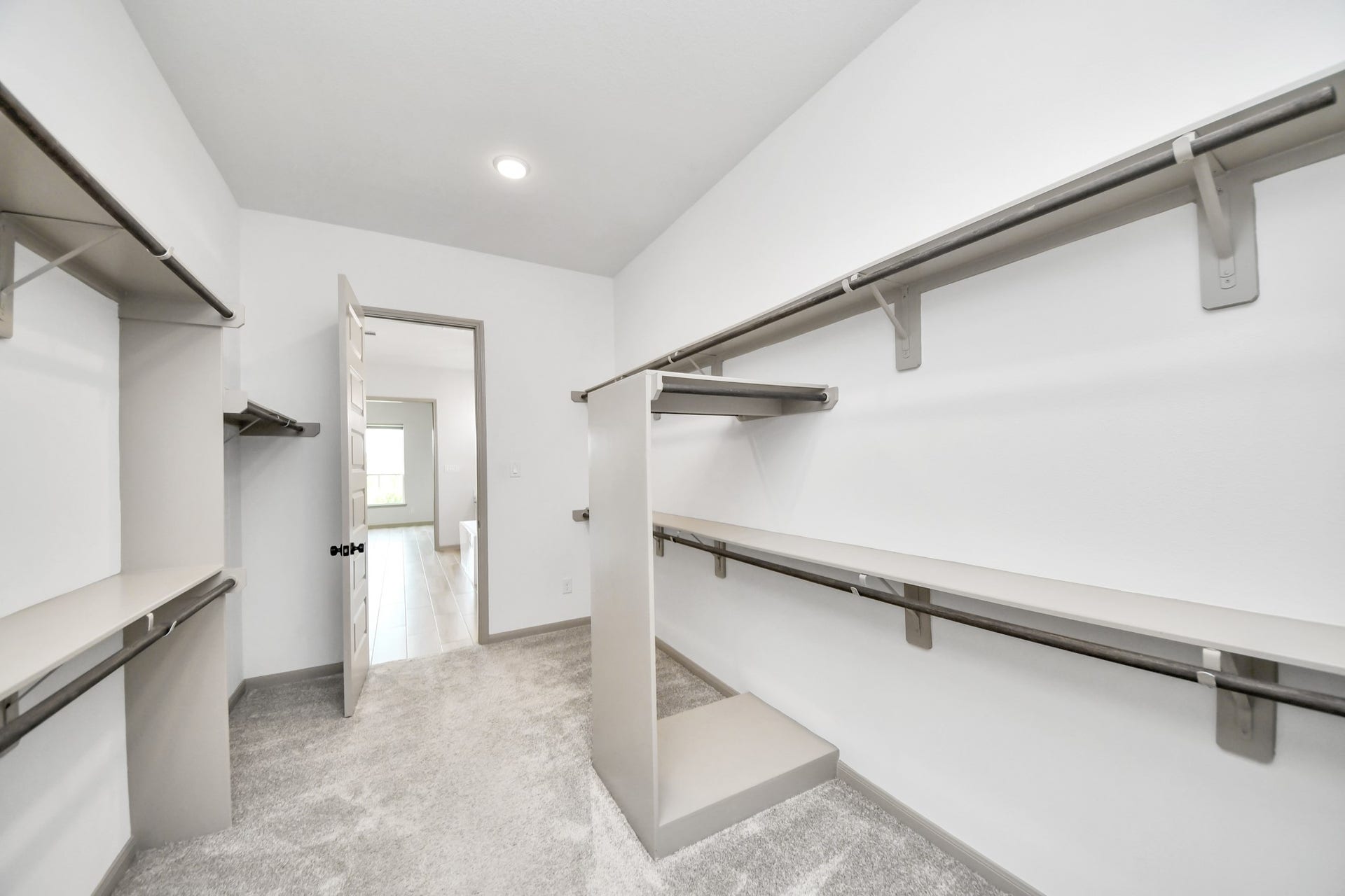 1423 Hackberry Heights Drive, Richmond, TX 77406 Spacious walk-in closet with ample shelving and hanging space, featuring carpeted flooring and modern lighting.