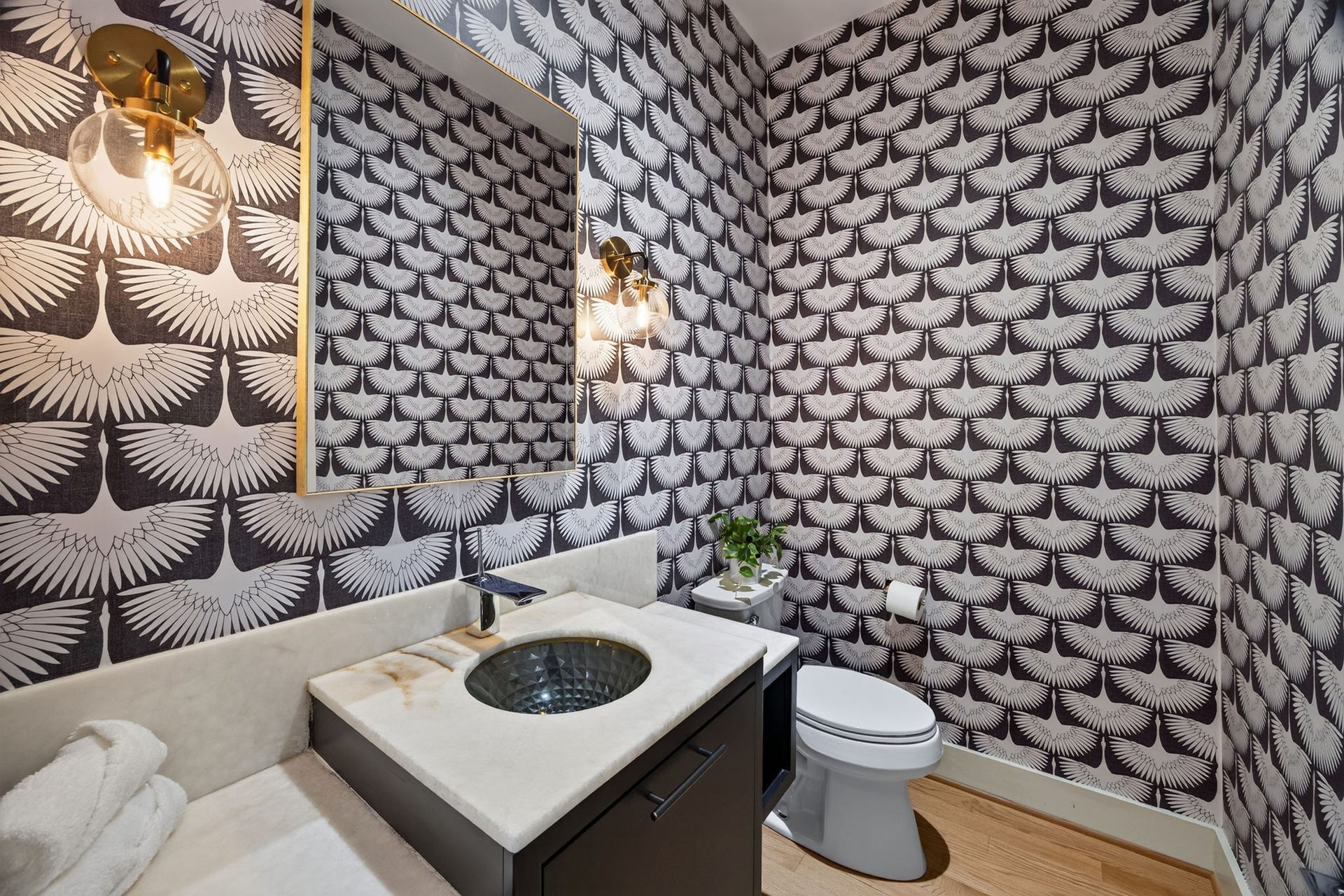 6002 Valley Forge Drive, Houston, TX 77057 Chic powder room with bold, patterned wallpaper and a modern vanity featuring a sleek, round sink and elegant lighting.
