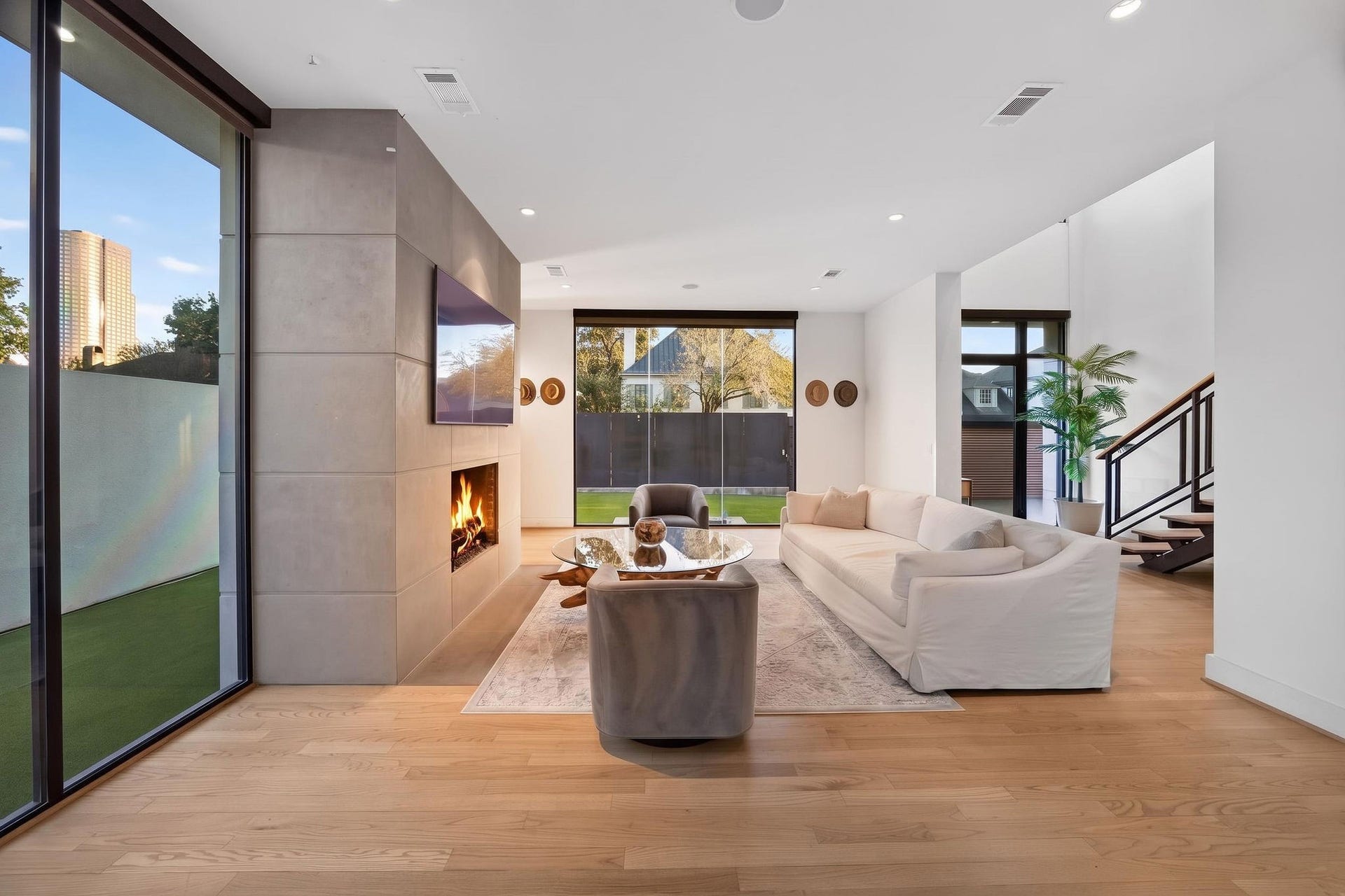 6002 Valley Forge Drive, Houston, TX 77057 Modern living space featuring a sleek fireplace and large windows that provide ample natural light.