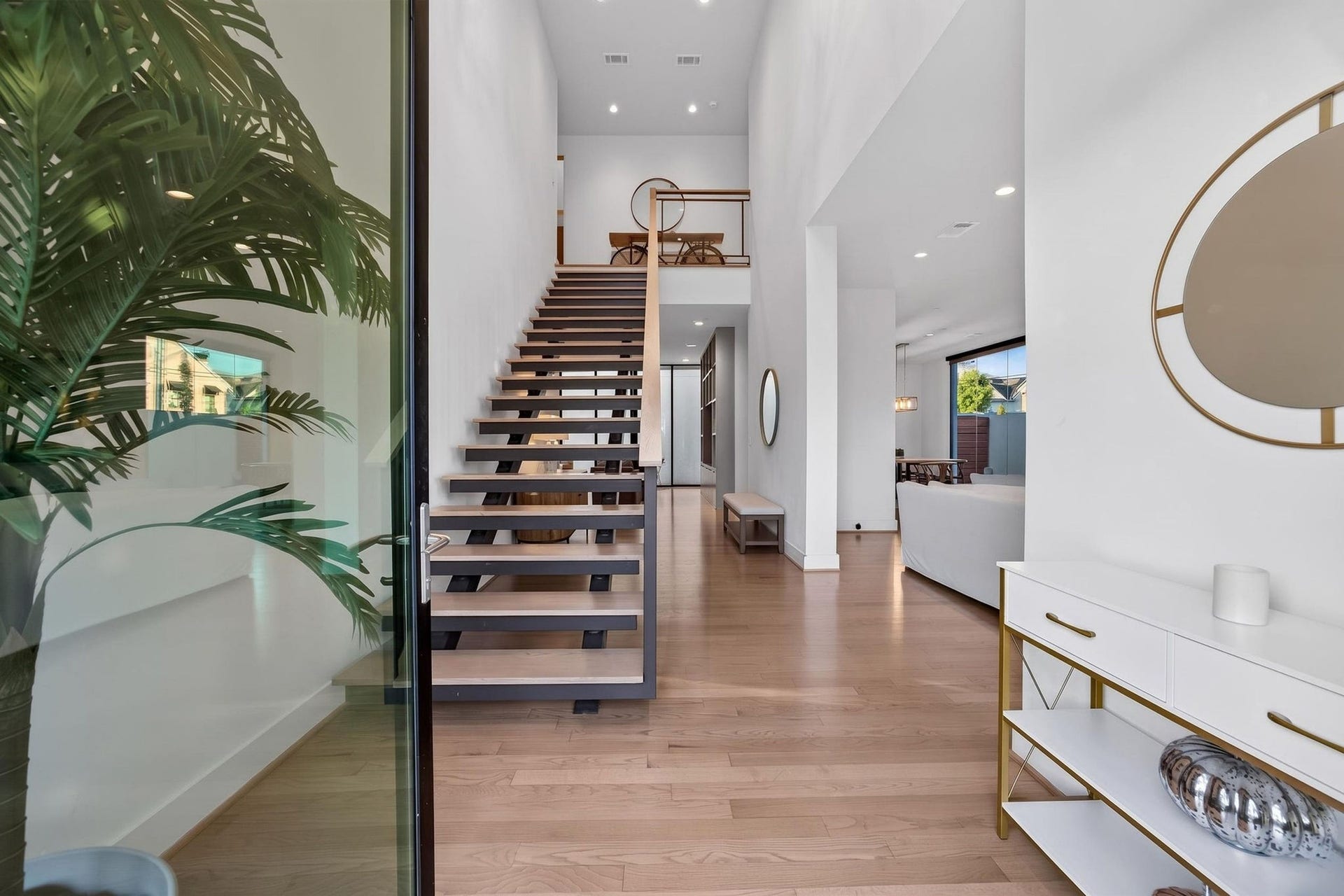 6002 Valley Forge Drive, Houston, TX 77057 Experience modern elegance in this stunning entryway, featuring a sleek open staircase, high ceilings, and abundant natural light, seamlessly flowing into the spacious living area.