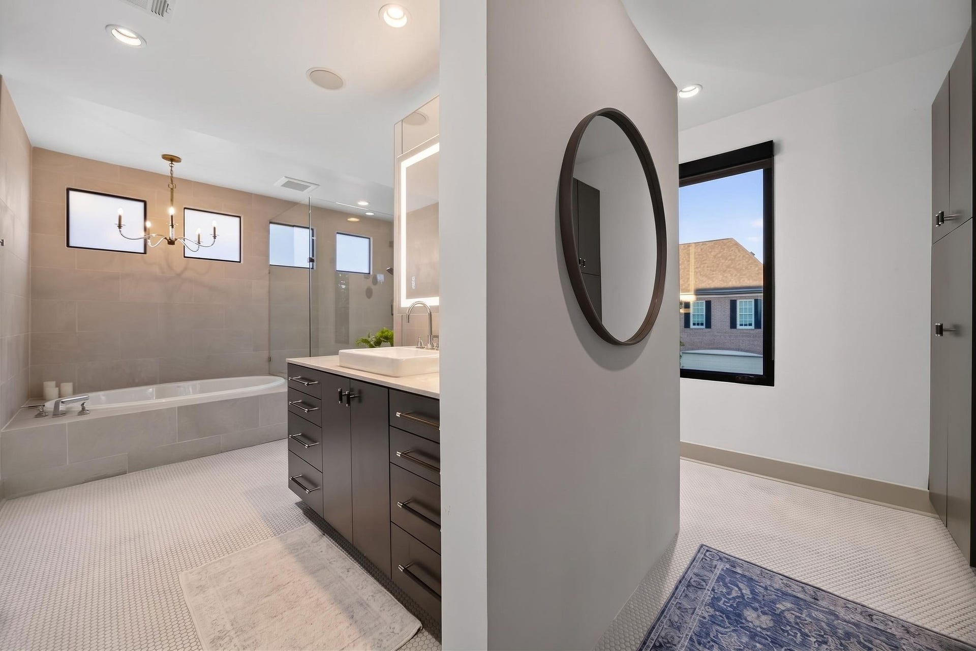 6002 Valley Forge Drive, Houston, TX 77057 Elegant bathroom with a modern design, featuring a spacious bathtub, sleek double vanity with ample storage, and large windows for natural light.